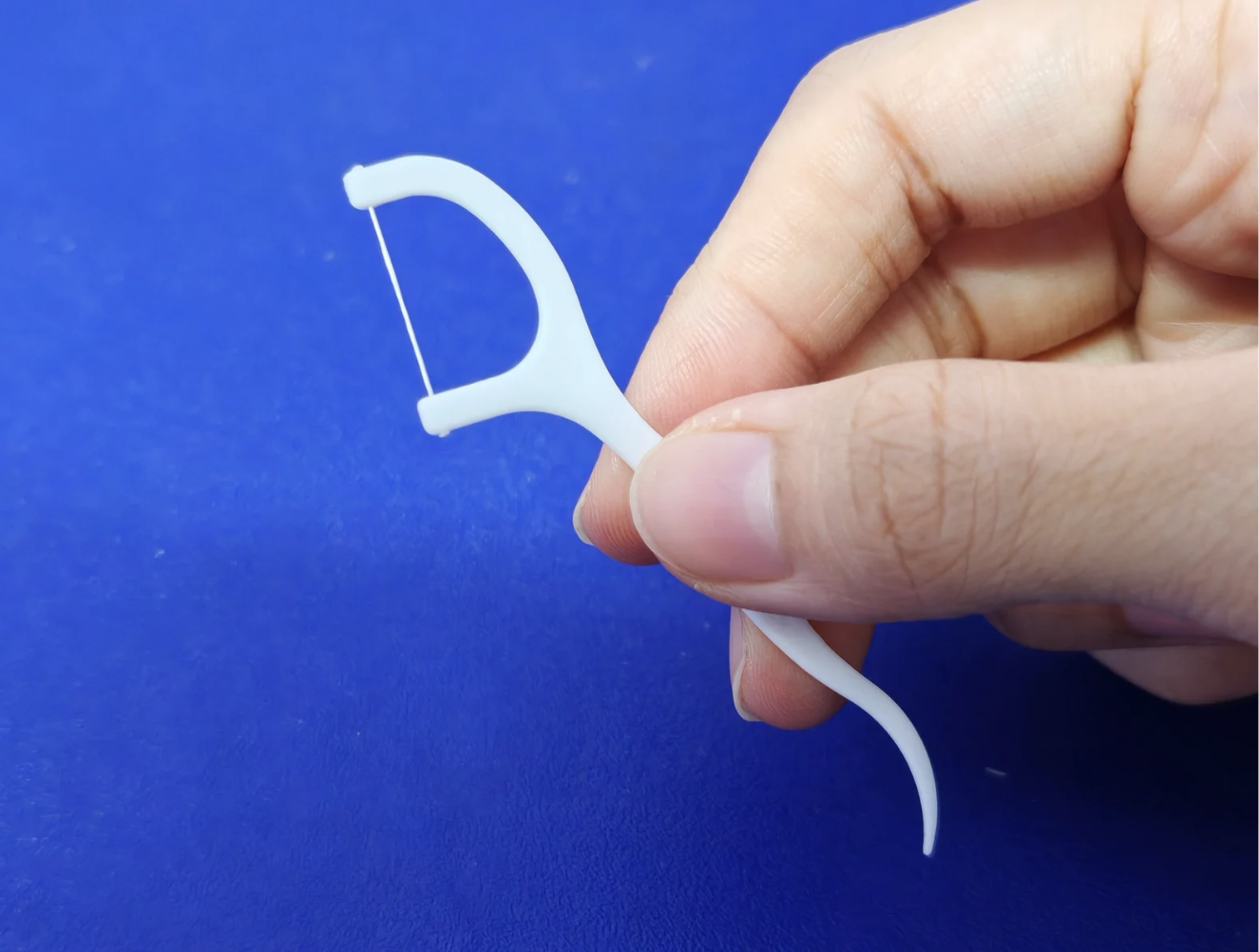 Hand holding a floss pick