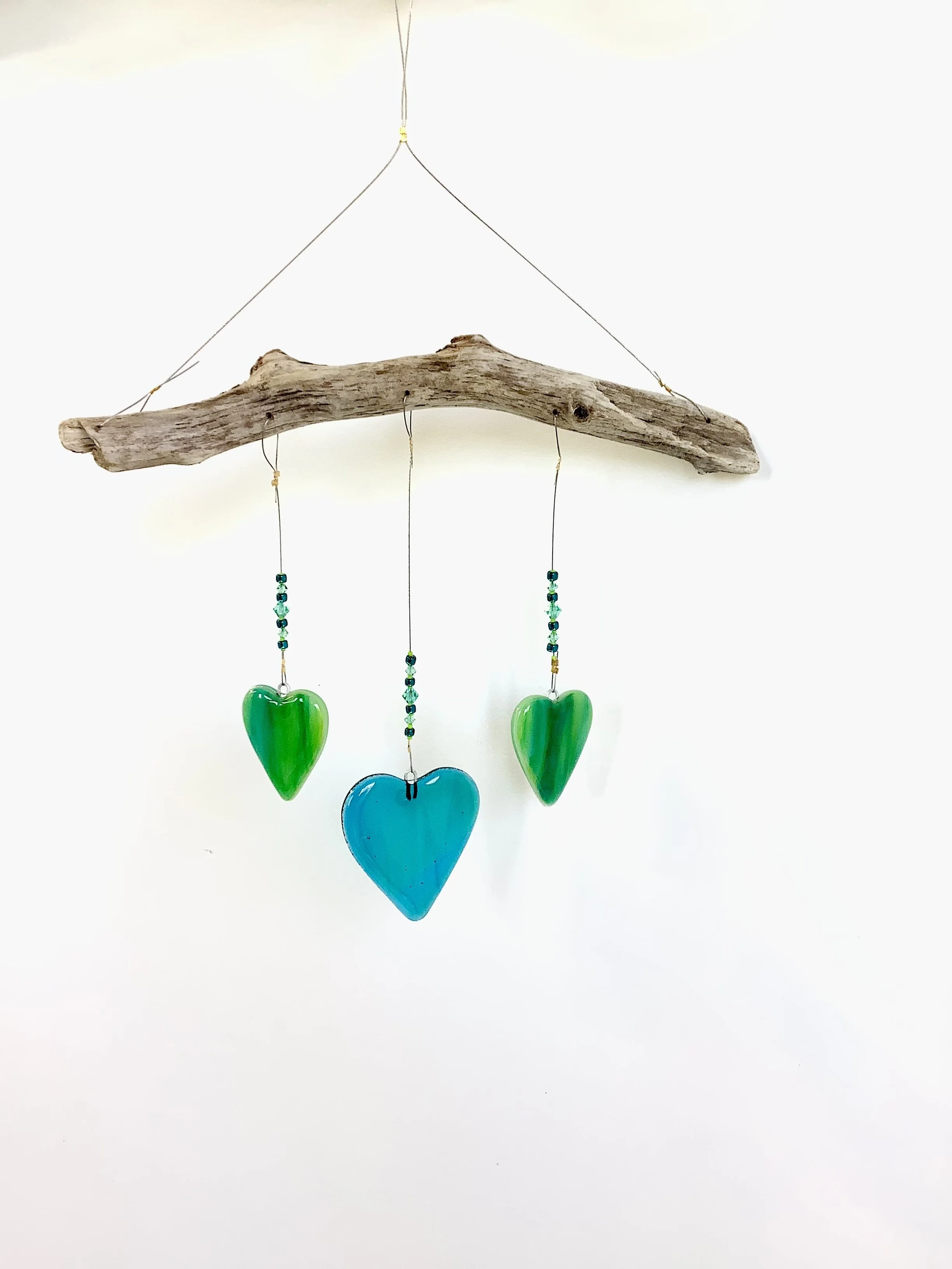 SOLD   $65
Swirly teals and blue heart mobile with teal and lime green beads. Middle heart is larger than two sides. Hangs 14"x9" from stainless wire and Vancouver Island driftwood. Contact to purchase.