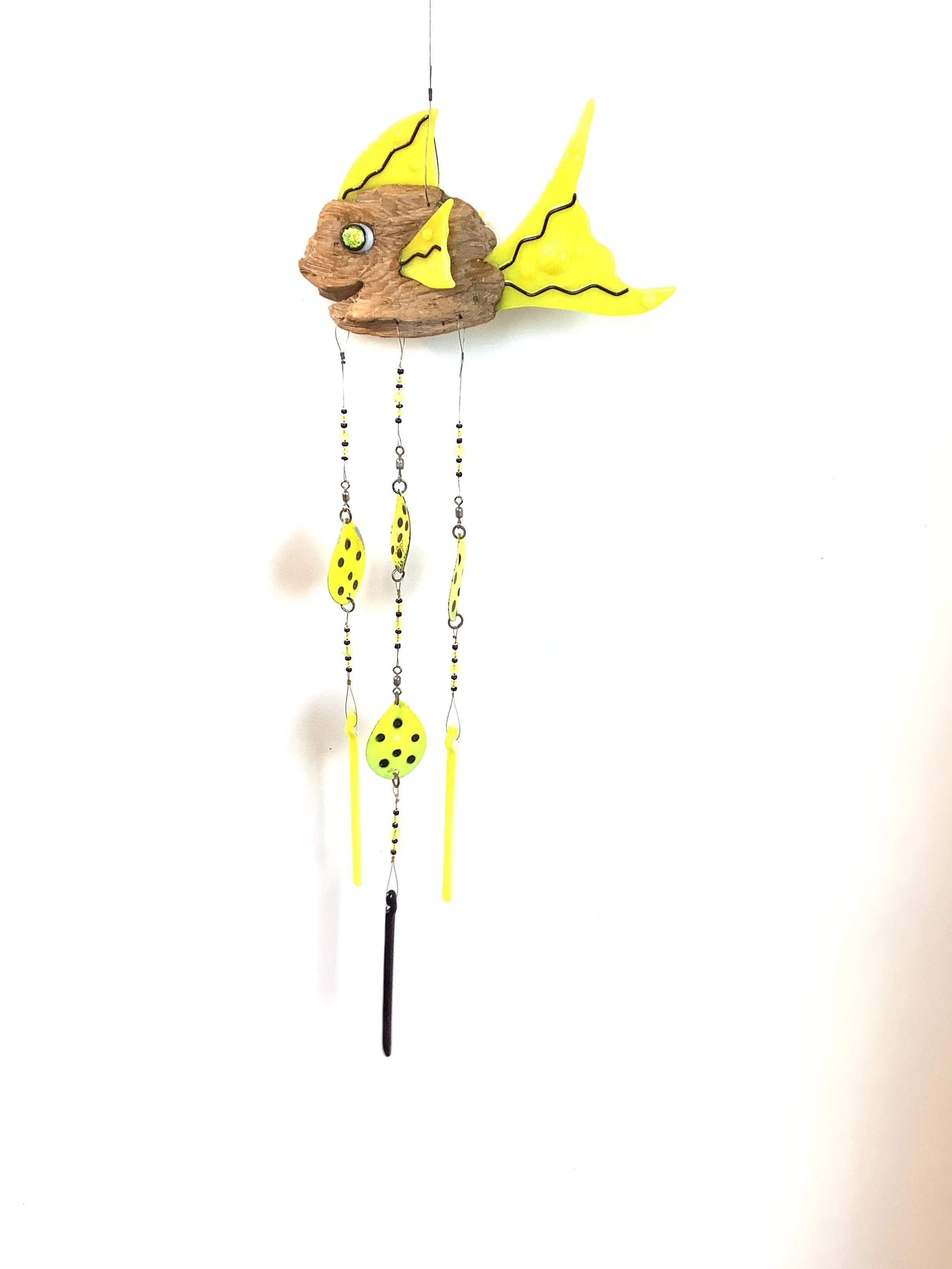 $130  " A reel catch"
Yellow fused glass driftwood fish chime with black squiggles and black and yellow beads. Hangs 33"x9" on stainless wire with  fishing lures and fused glass chimes. Contact to purchase.