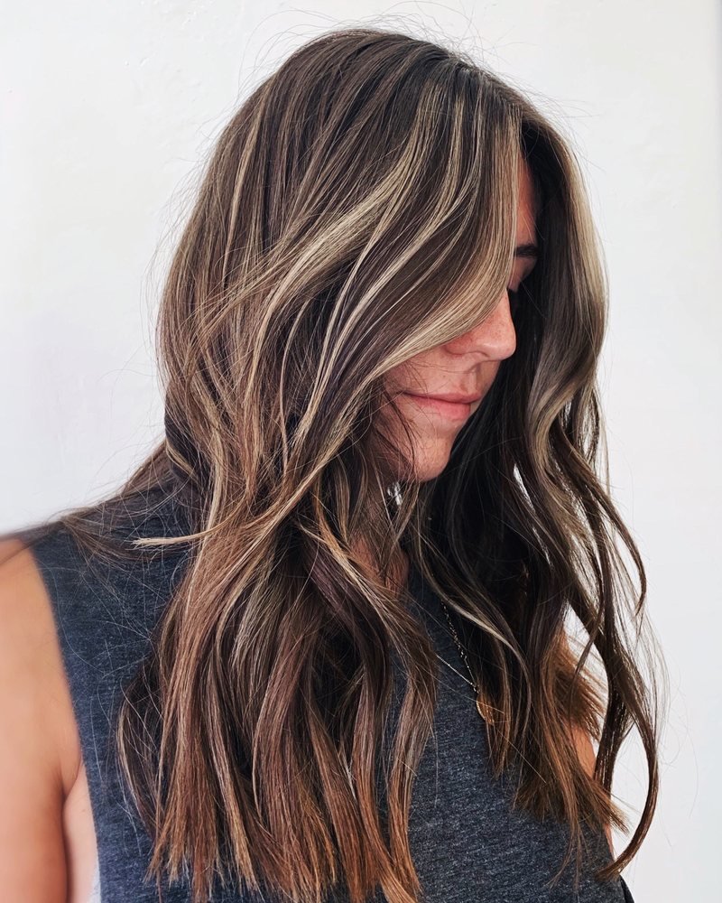 Long hair with blended ash tone highlights styled at The Co-Artist Studio in Capitola, California, featuring soft blonde dimension and natural root melt.