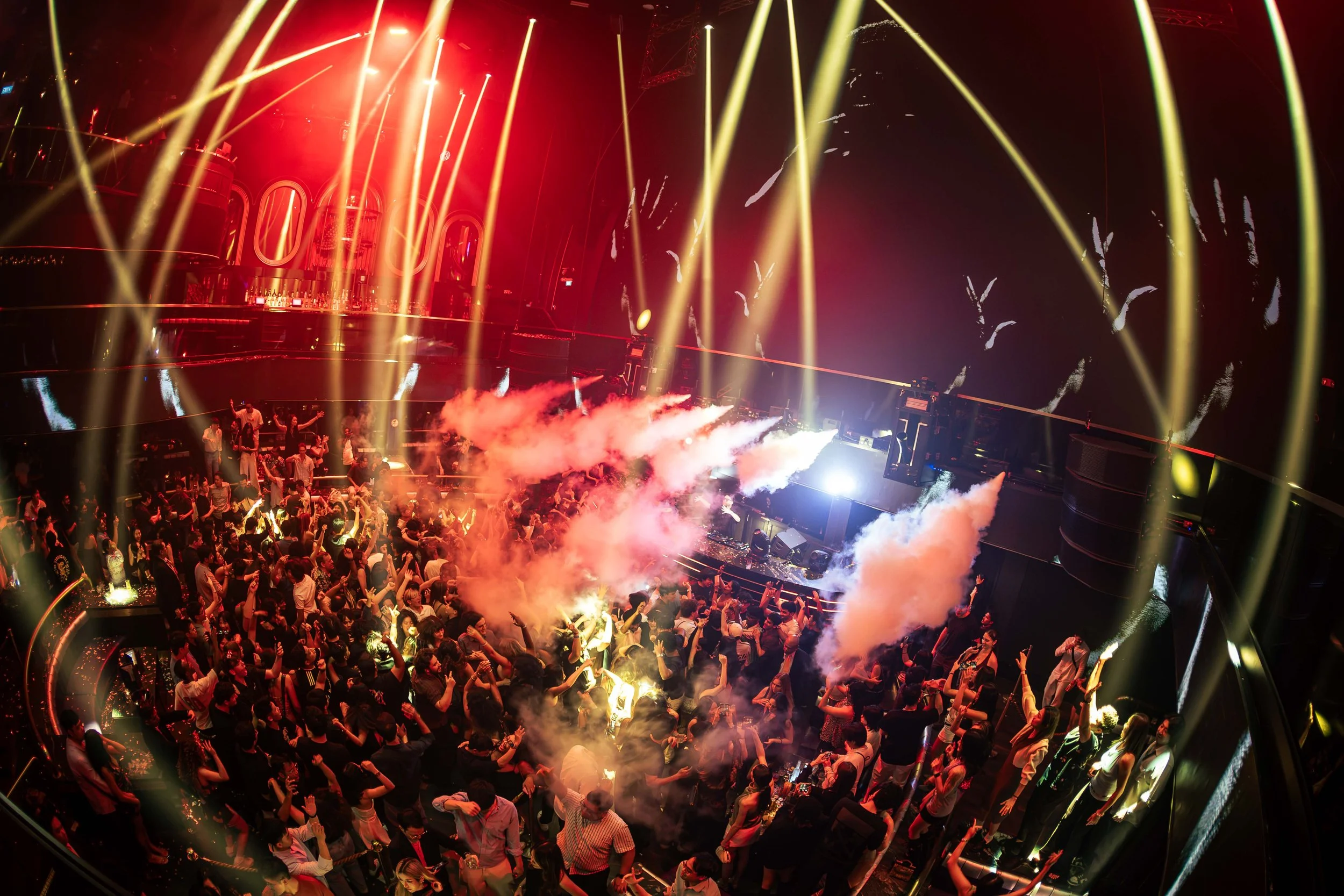 Mr.J DJ performing live at Marquee Singapore as golden laser beams and CO2 effects fill the venue above a packed crowd during a high-energy electronic dance music performance.