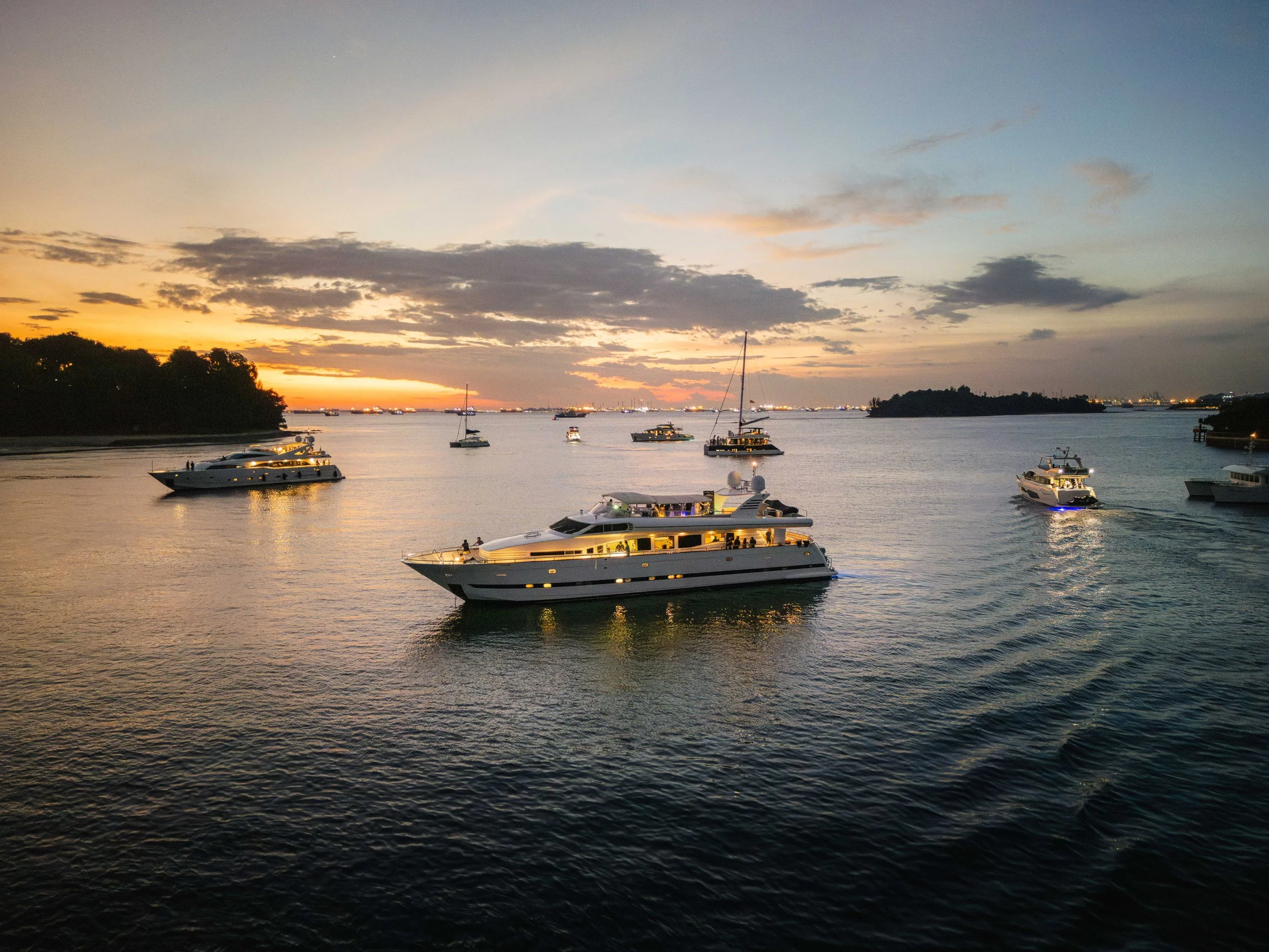 Luxury yachts cruising through Singapore's Southern Islands at sunset, showcasing a premium waterfront setting for yacht events, private charters and luxury lifestyle experiences.