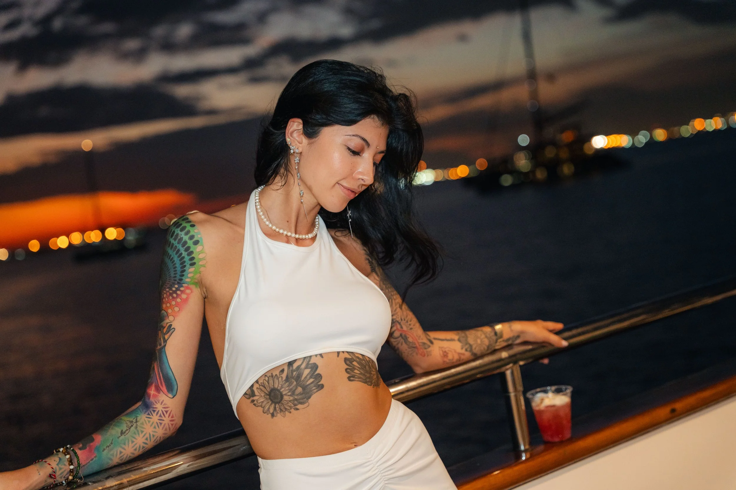 Guest posing aboard a luxury yacht at sunset in Singapore's Southern Islands, captured in an elegant lifestyle portrait overlooking the waterfront during a private yacht event.