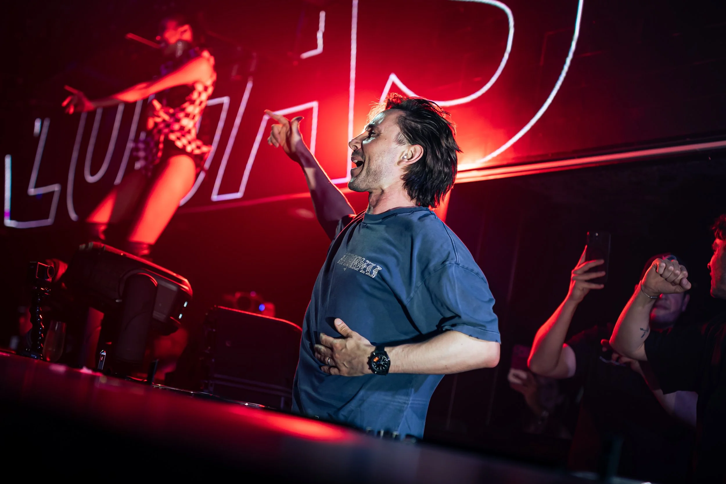 DJ Lucas & Steve performing live at Marquee Singapore as Lucas hypes the crowd beneath dramatic red stage lighting during an energetic electronic dance music performance.