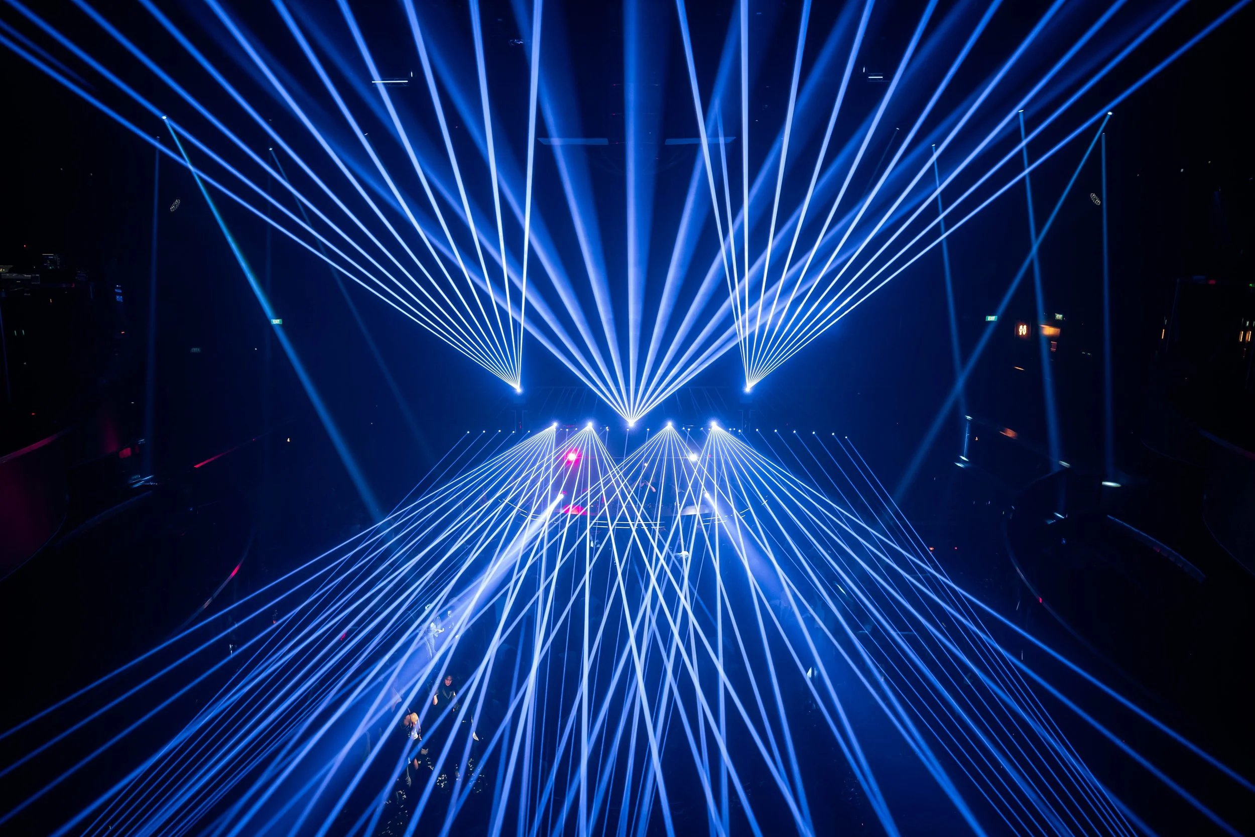 Blue laser beams illuminate Marquee Singapore during DJ Lucas & Steve's live performance, creating an immersive electronic dance music atmosphere above a packed dance floor.