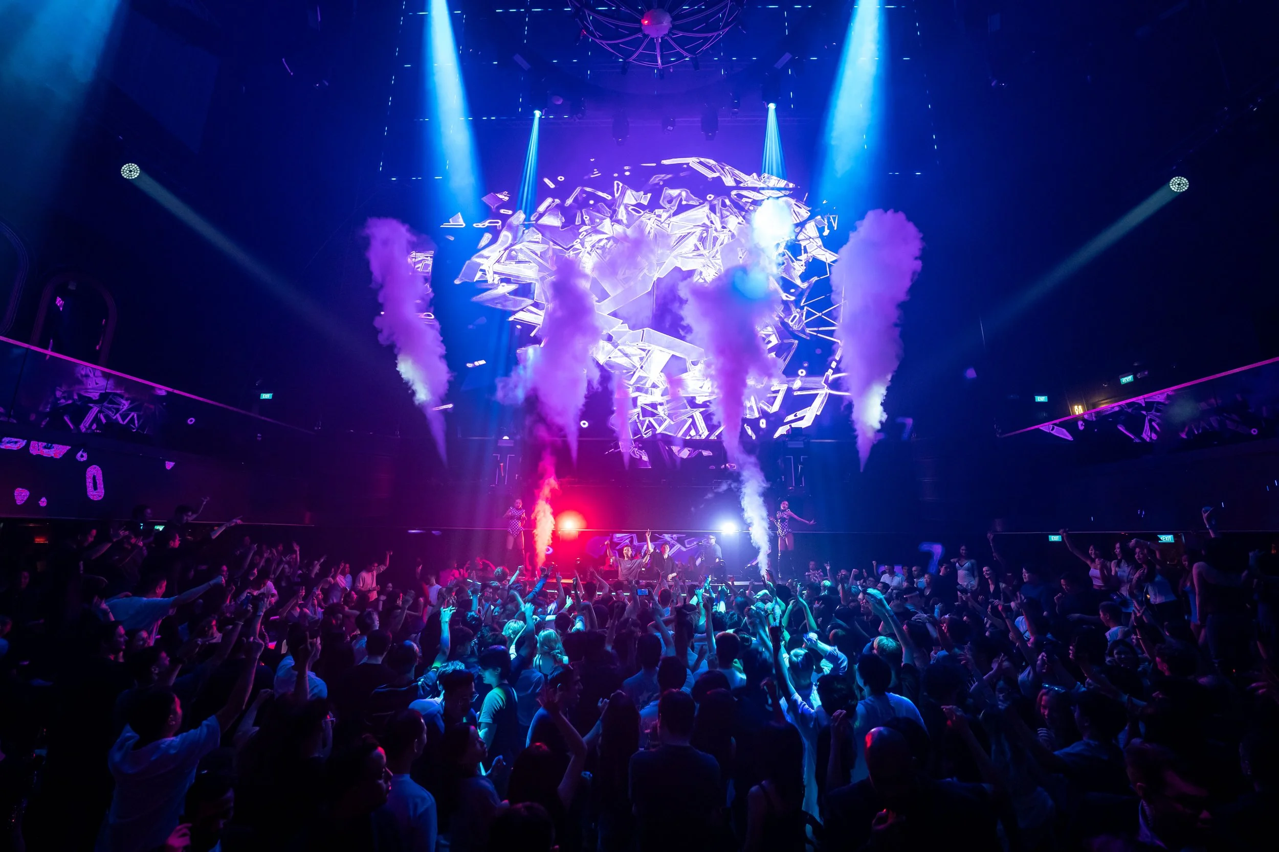 Packed crowd enjoying DJ Lucas & Steve's performance at Marquee Singapore beneath dramatic CO2 effects, immersive LED visuals and vibrant blue stage lighting during a live electronic dance music event.