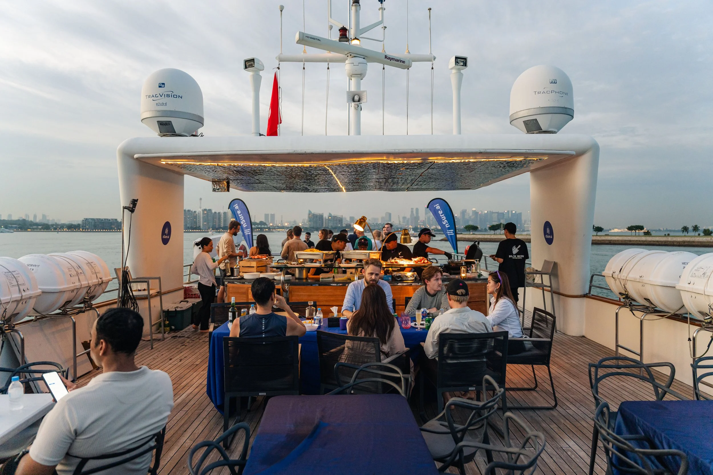 Guests dining and networking aboard a luxury yacht in Singapore's Southern Islands, capturing a premium waterfront setting for corporate events, private celebrations and yacht experiences.