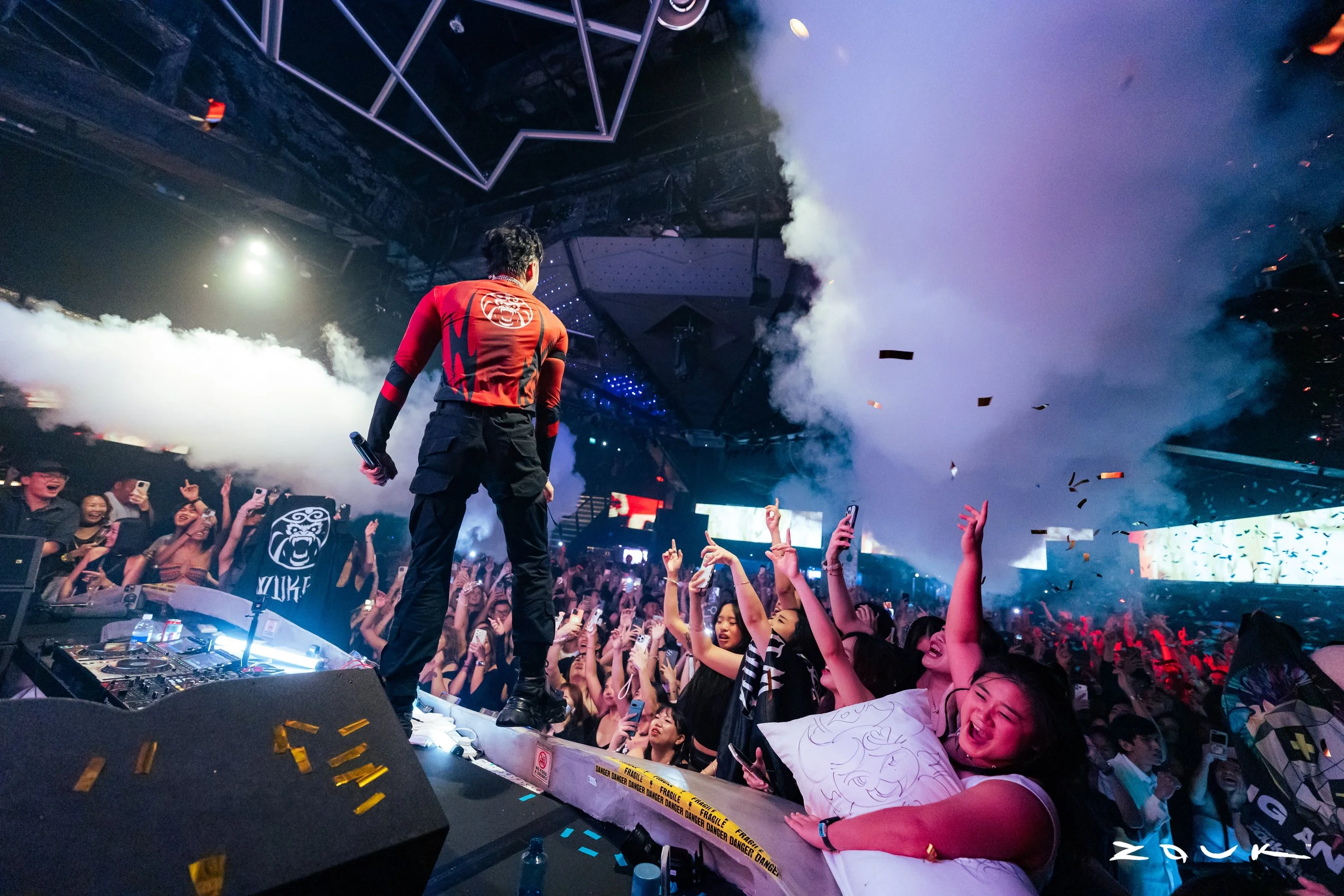 DJ Wukong performing live at Zouk Singapore as CO2 cannons erupt above a packed crowd, creating an electrifying nightclub atmosphere with immersive stage production and energetic audience interaction.
