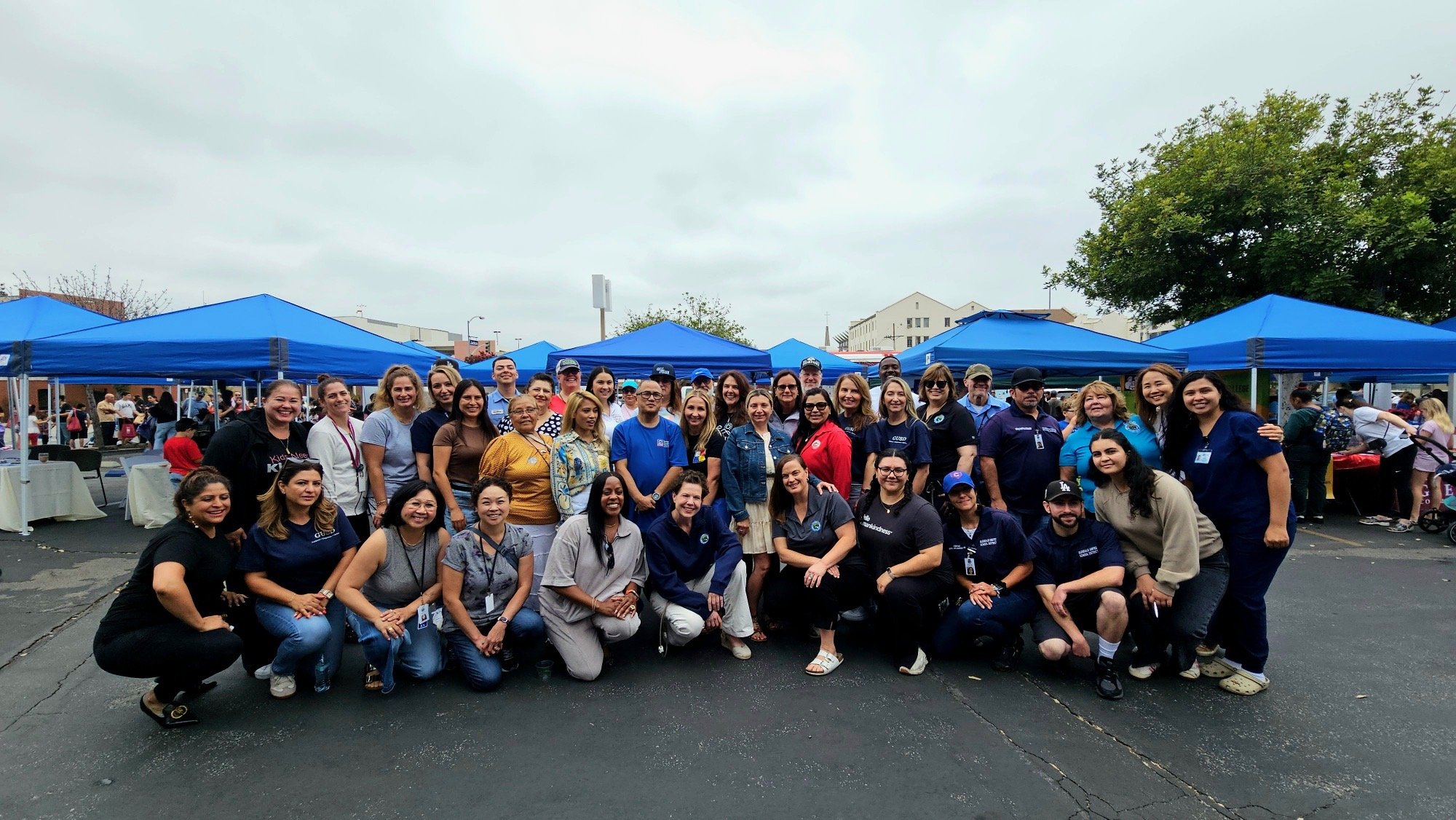 Kathleen Cross GUSD board member smiling in a group of staff and teachers and families.