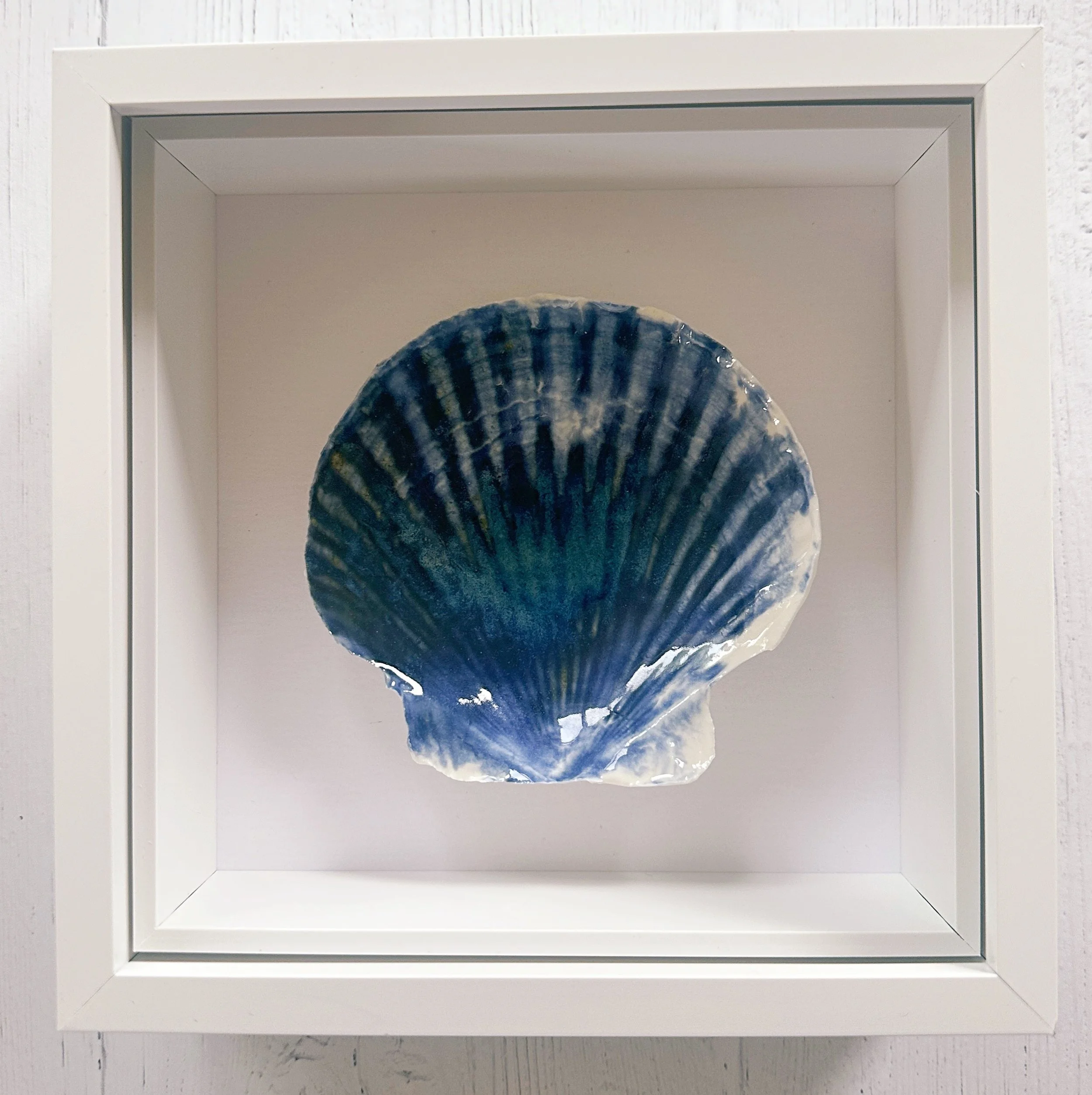 This textured coastal wall art features handcrafted porcelain shell art, creating a unique piece of beach art inspired by the Sussex coastline
