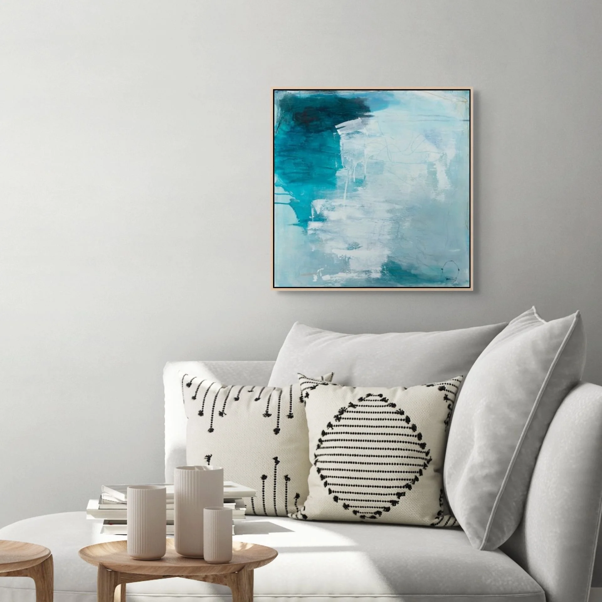 Seafoam, framed, abstract art print in shades of blue and white by Laurie Baars, shown in a living room.