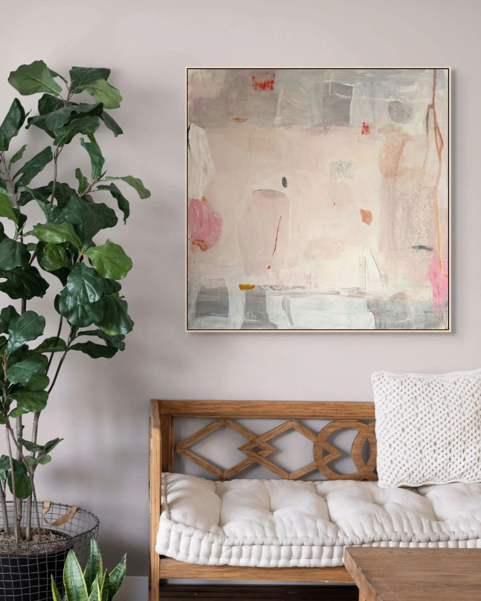 Pink, gray, and cream framed, square abstract art print on canvas by Laurie Baars, shown in a living room.