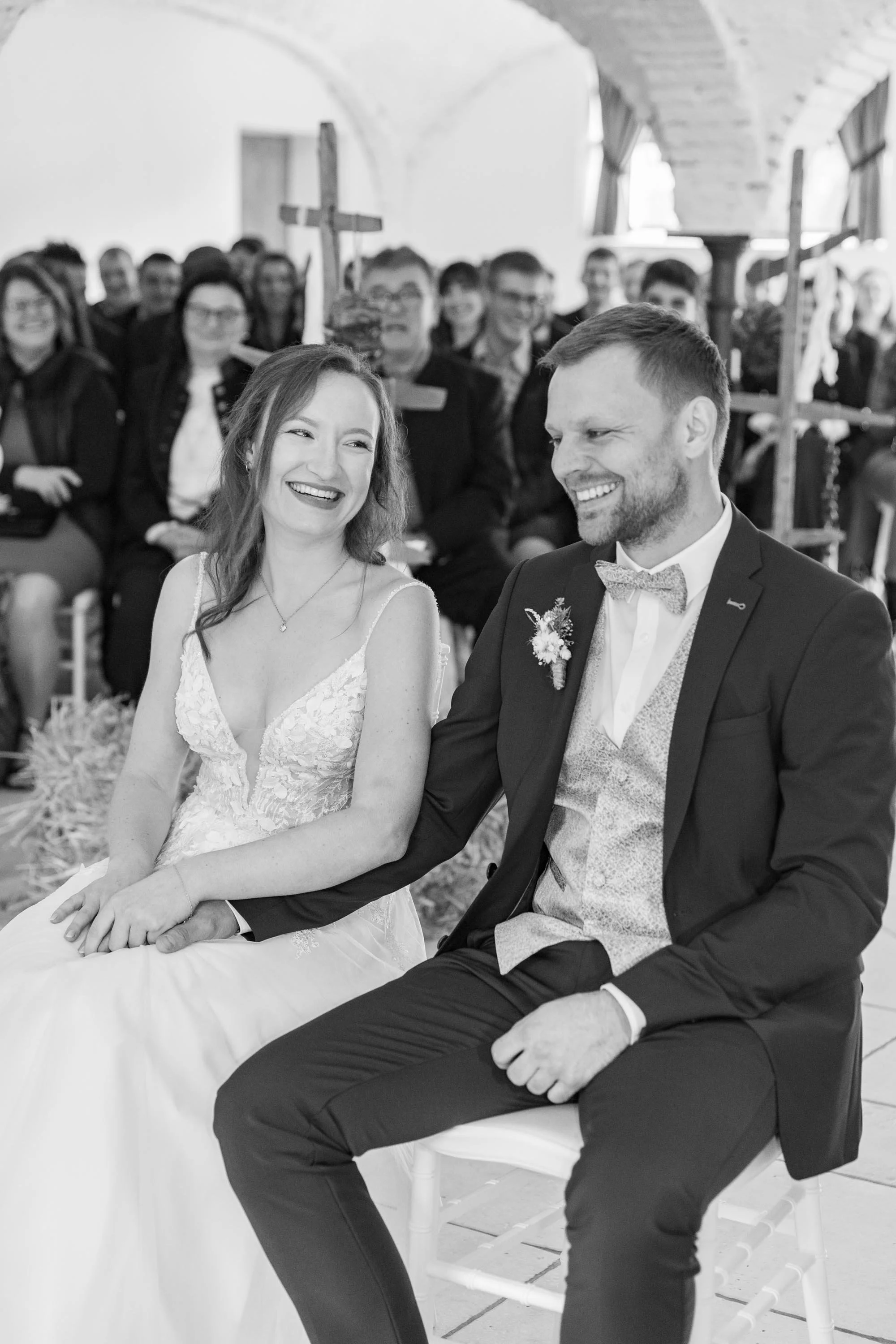 emotionales Hochzeitsreportagenfoto vom Brautpaar während der Trauung, beide lachen, es ist ein Foto in schwarz-weiß