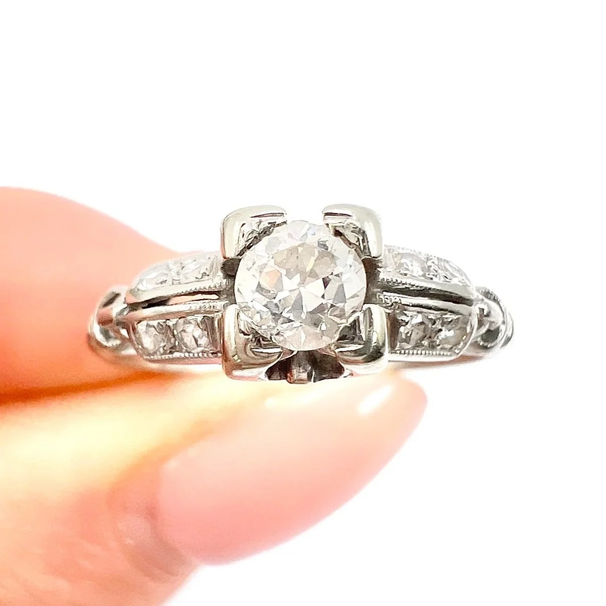 Close-up of a large round diamond centre stone and smaller diamonds on the band.
