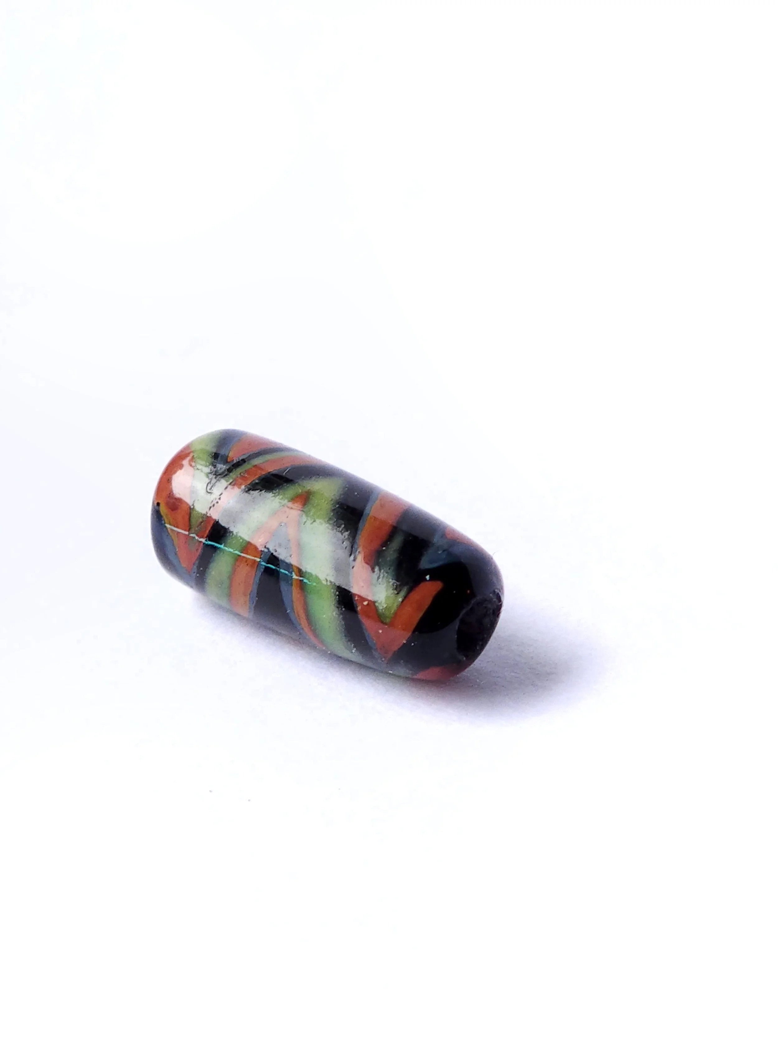 Halloween colors zig zag gravity tunnel bead. Lampworked glass bead for Halloween with green, orange, and black. 