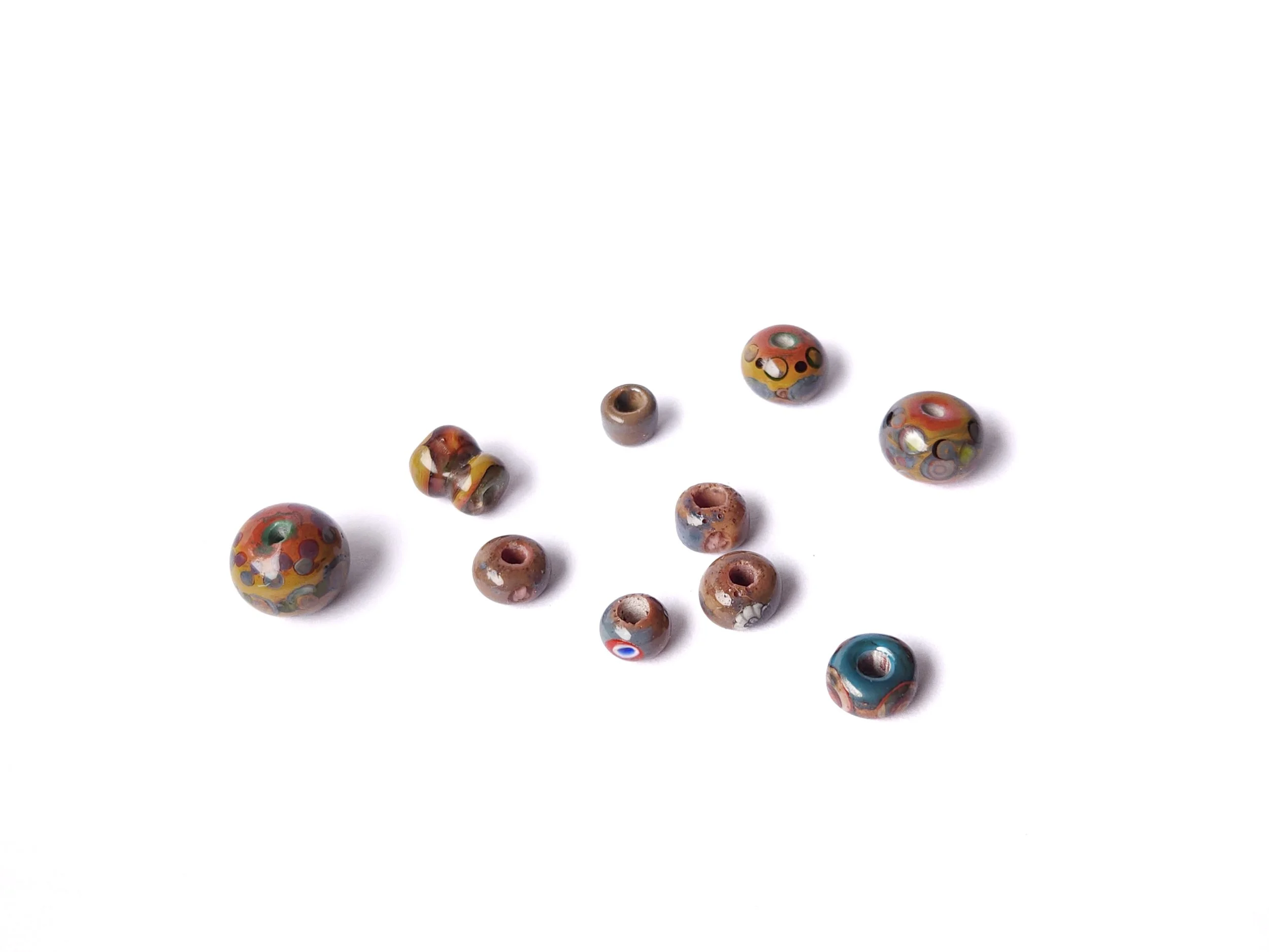 Selection of glass lampworked beads in natural earth tones. 