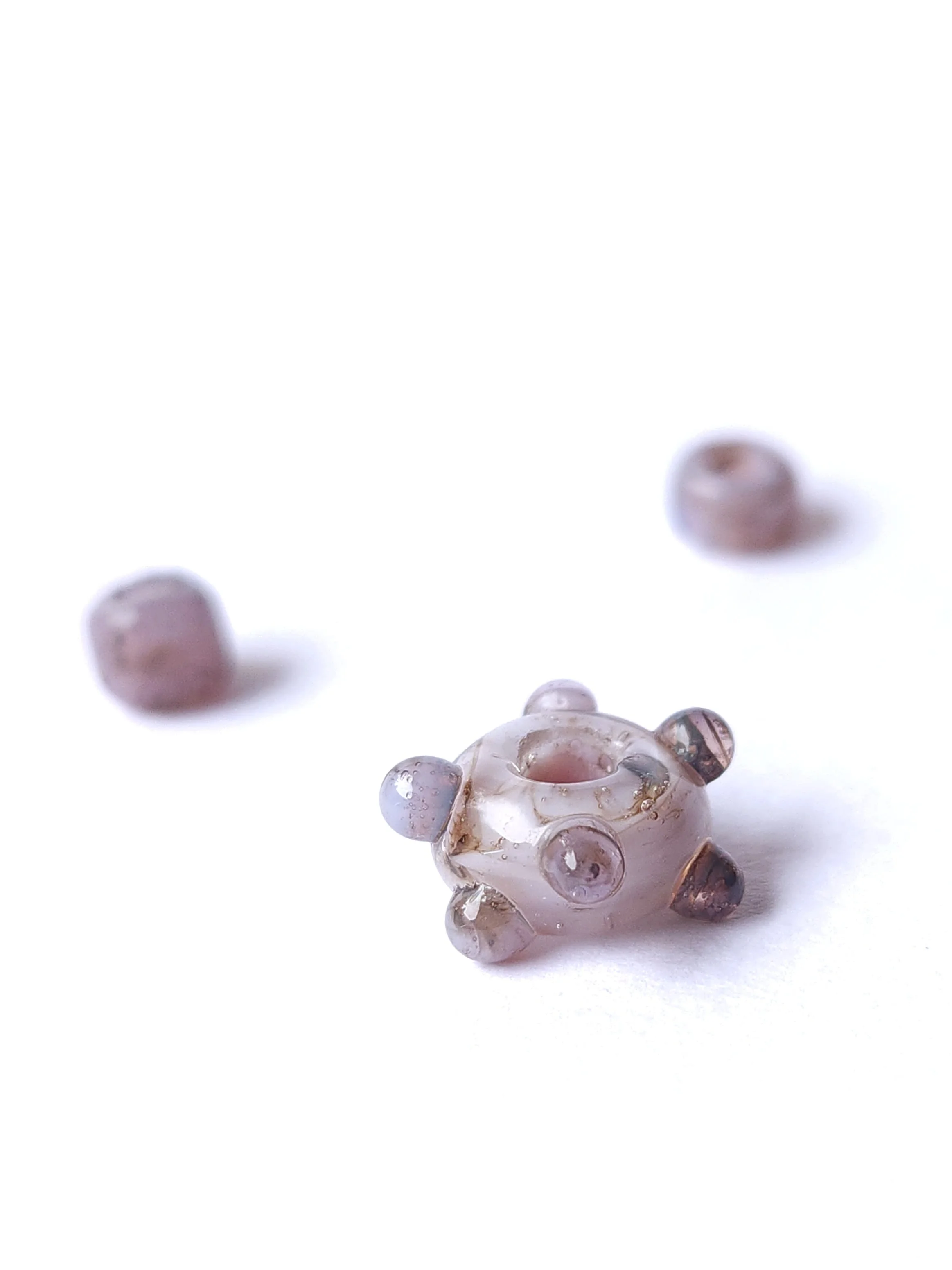 Clear and opal colored lampworked glass beads.