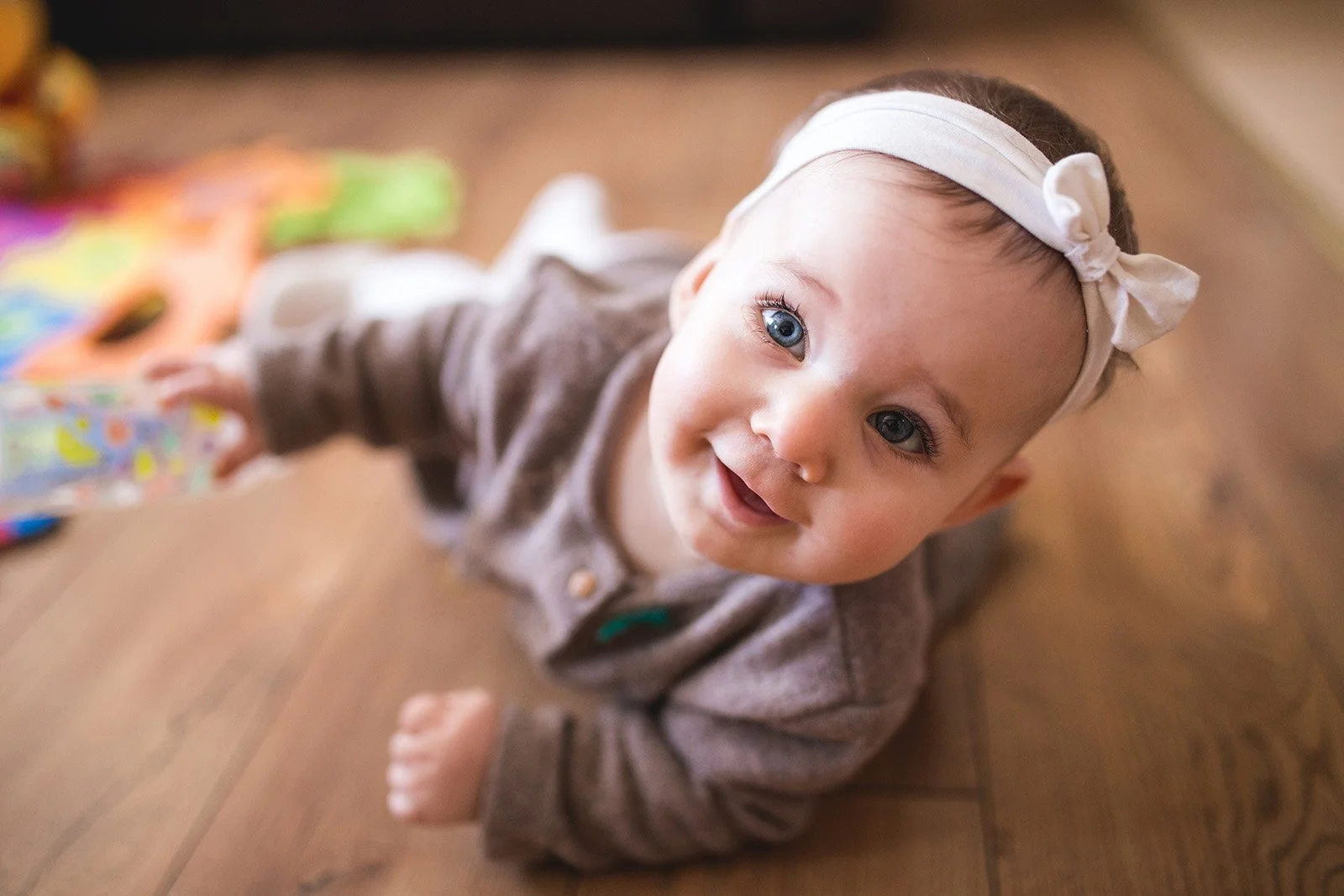 Baby crawling while looking up and smiling.jpeg
