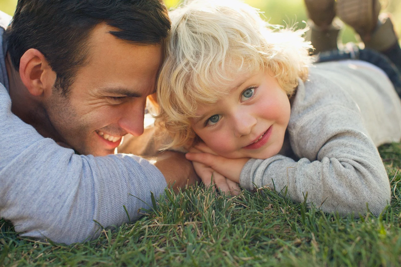 Father and son laying together in the grass.jpeg