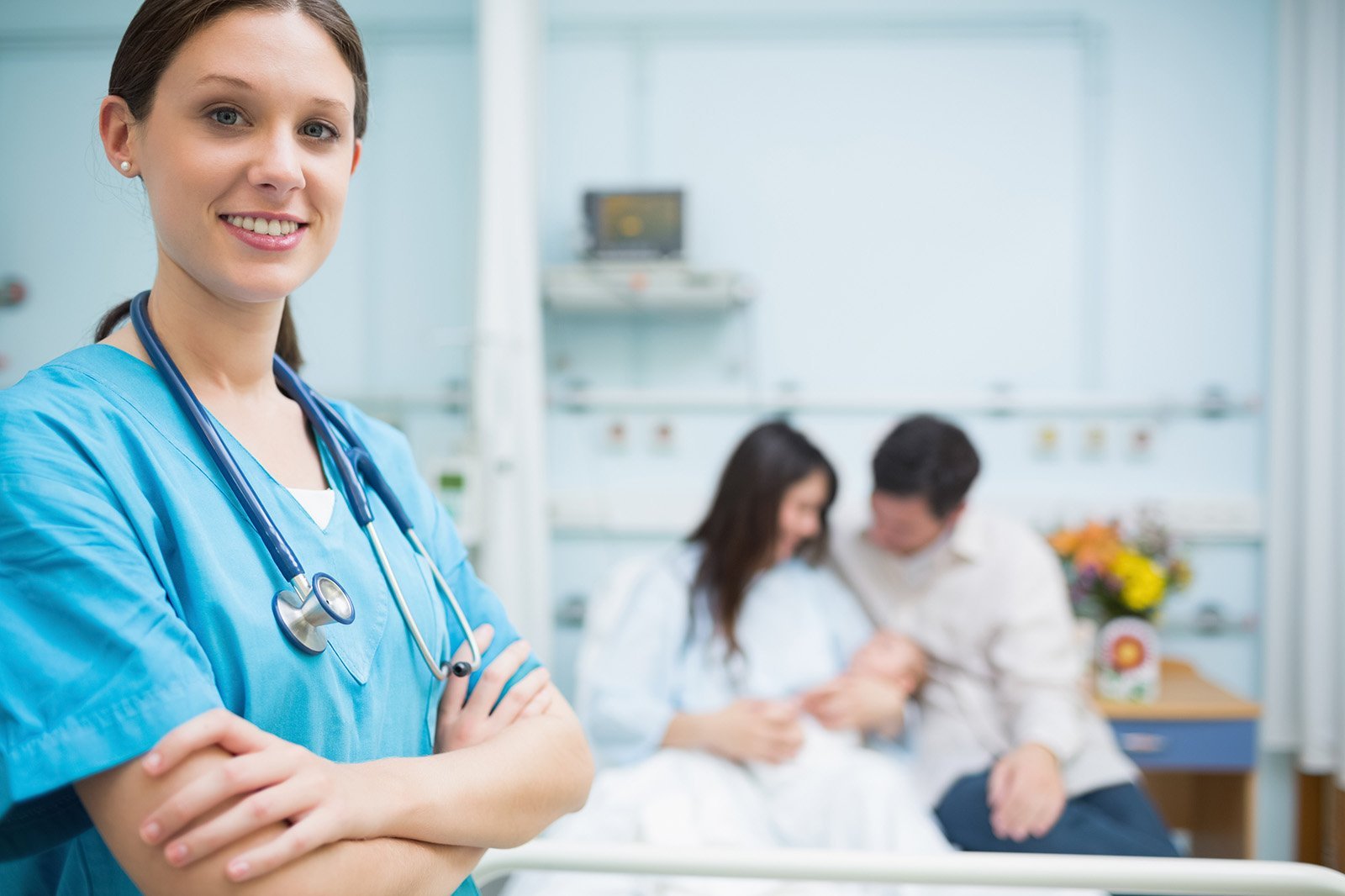 Nurse smiling while parents hold newborn baby.jpeg