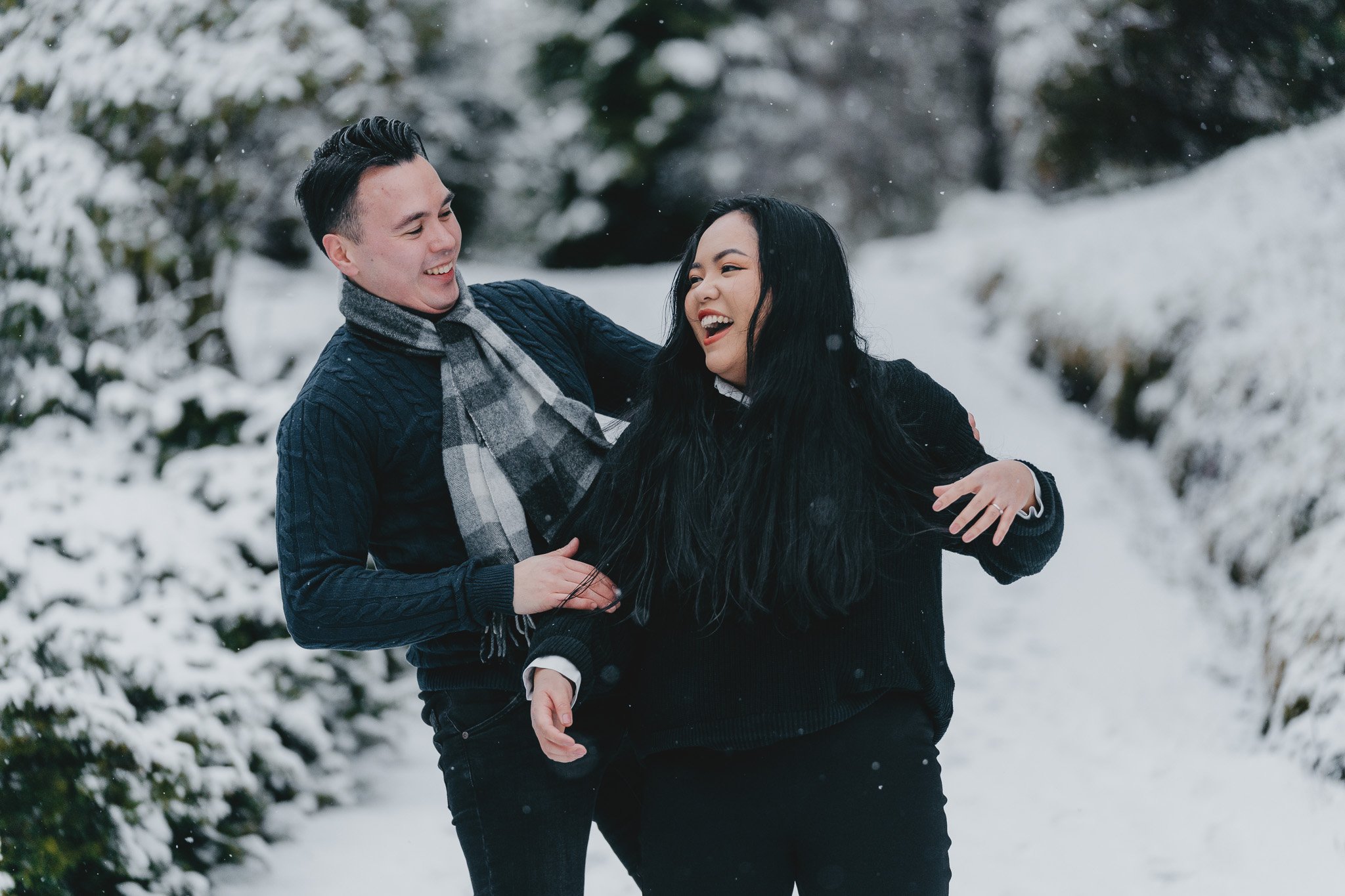 Et kjærestepar herjer i snøen mens de ler.
