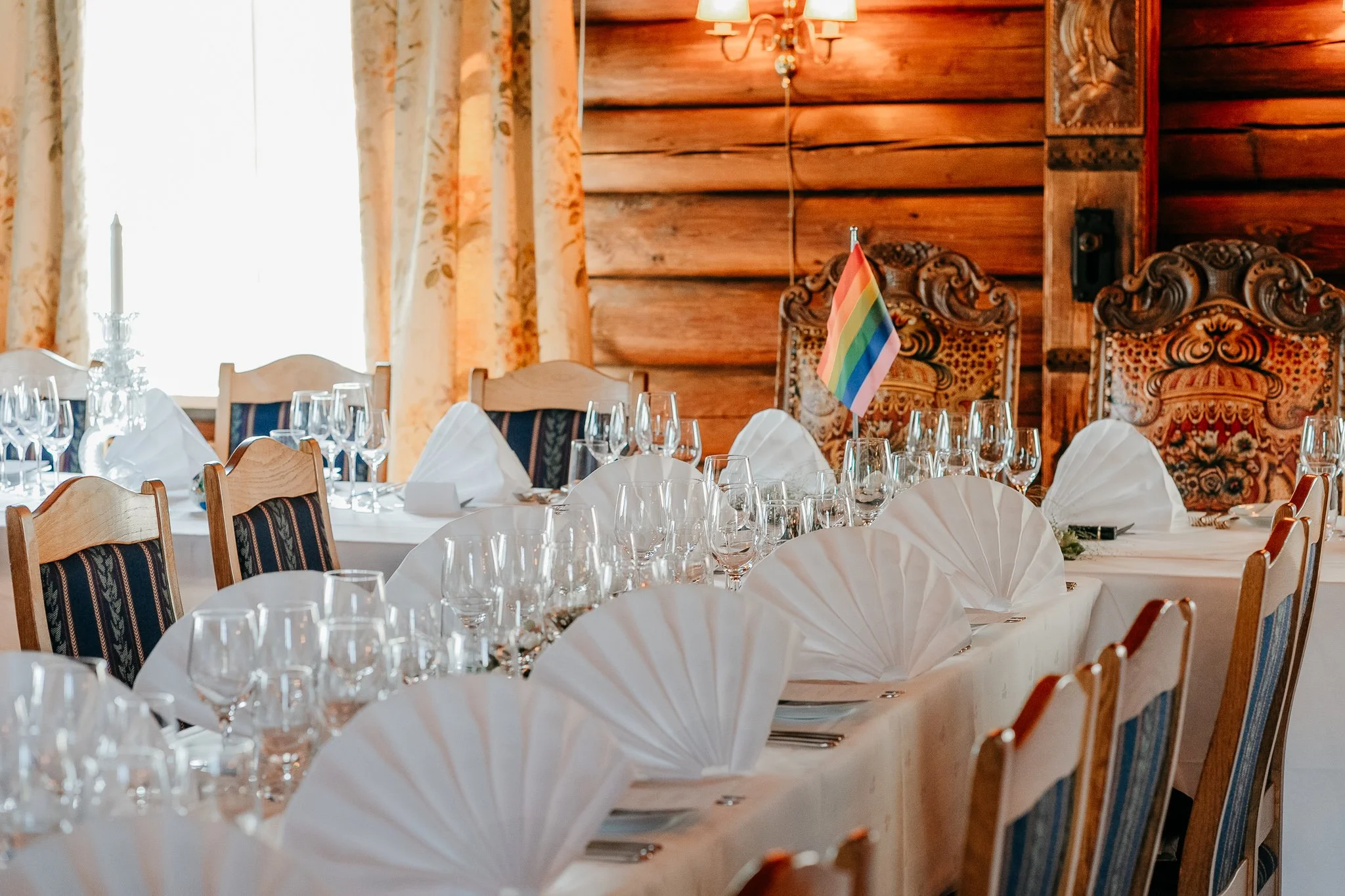 Bord dekket til fest og et regnbueflagg i midten.