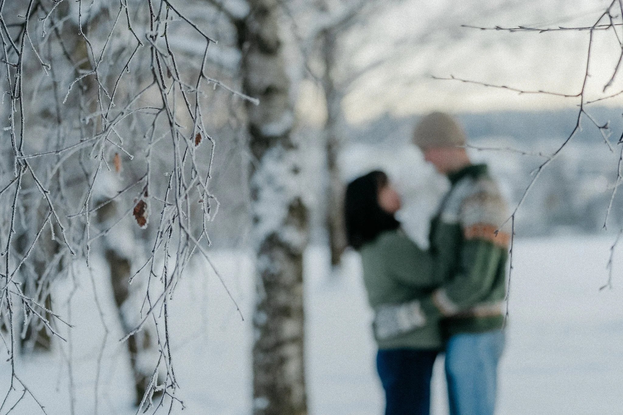 Bilde av en snødekt greit med to personer som holder rundt hverandre i bakgrunnen.