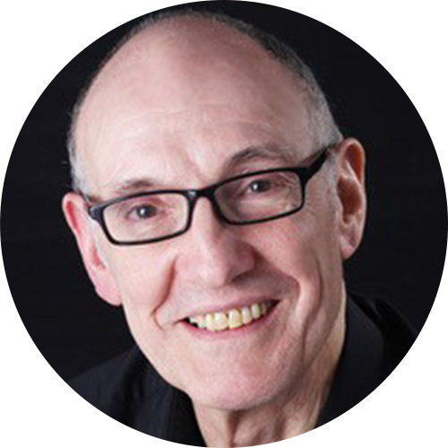 Black and white portrait of a smiling man with glasses and short hair.