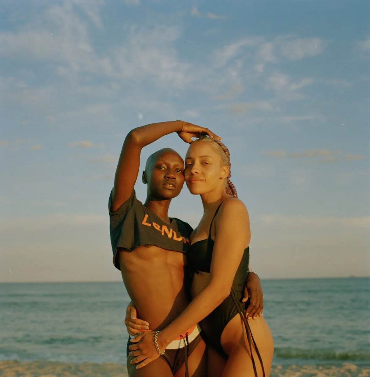 sukhpreet's photography of two melenated people embracing in front of the ocean