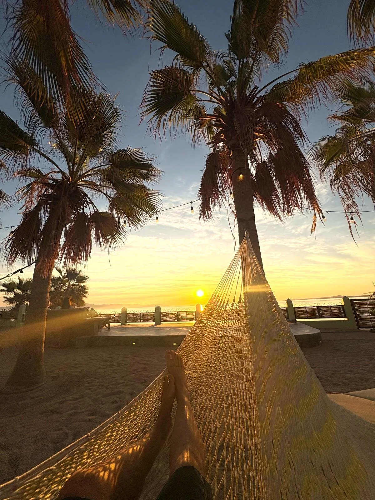 Legs resting on a hammock, sunrise