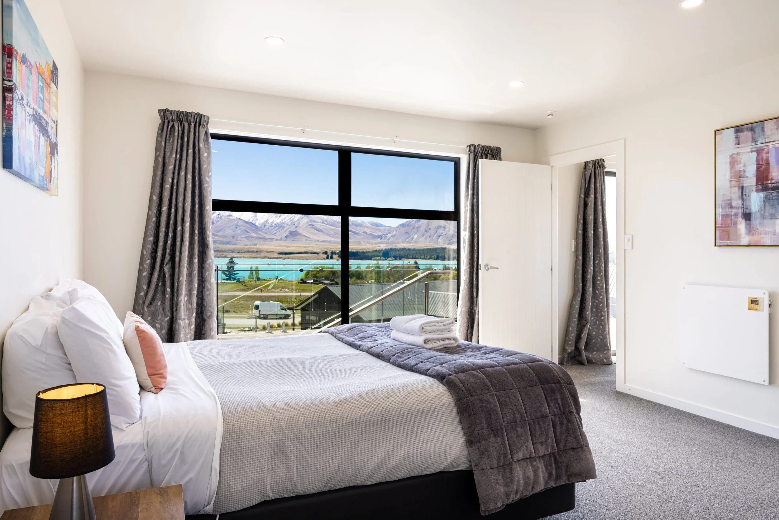 Well-lit bedroom with large windows and soft furnishings.jpg