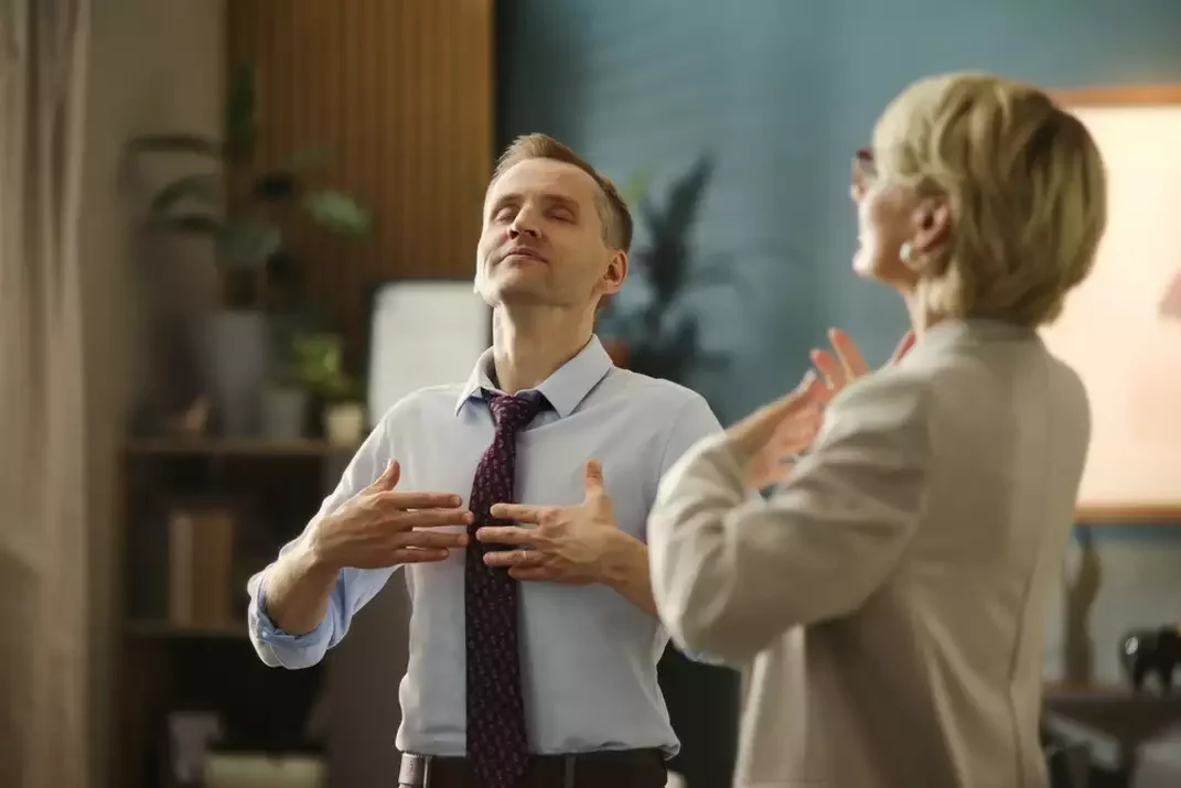 Therapist guides a client through a slow breathing exercise during a calm office session.