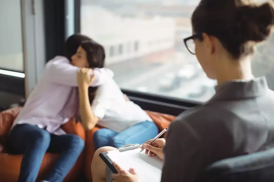 A couple embraces during a relationship therapy appointment.