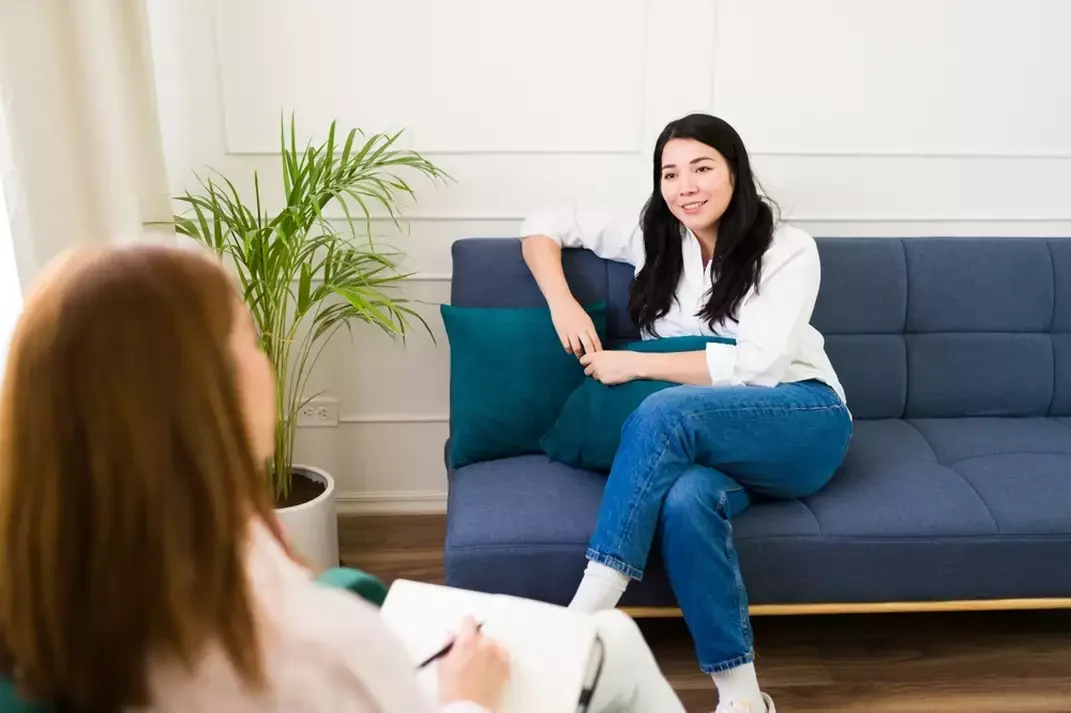 Client talks with a therapist in a bright, comfortable office during a supportive counselling session.