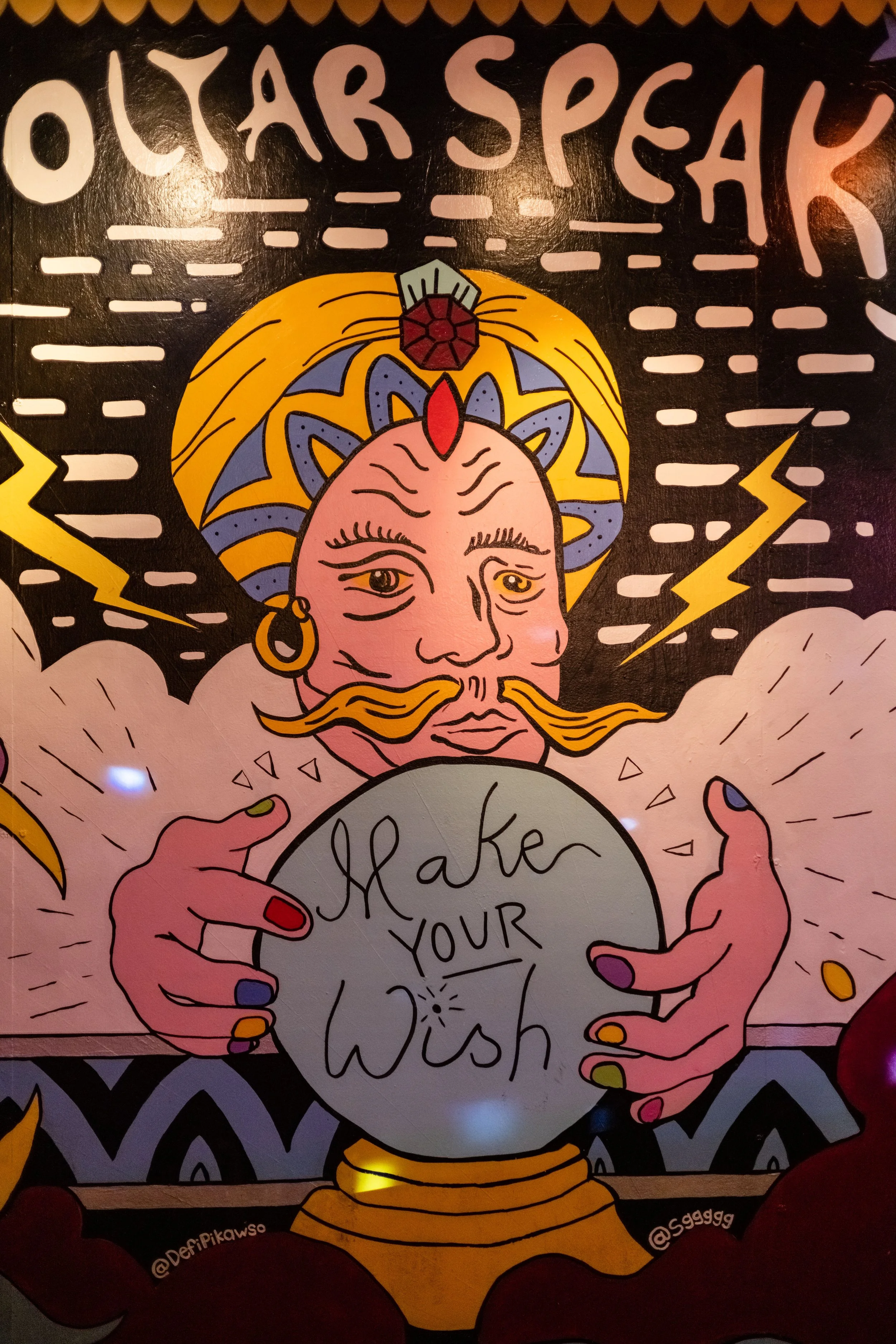 Colorful illustration of a fortune teller with a turban holding a crystal ball that says "Make Your Wish.", with lightning bolts and stars.