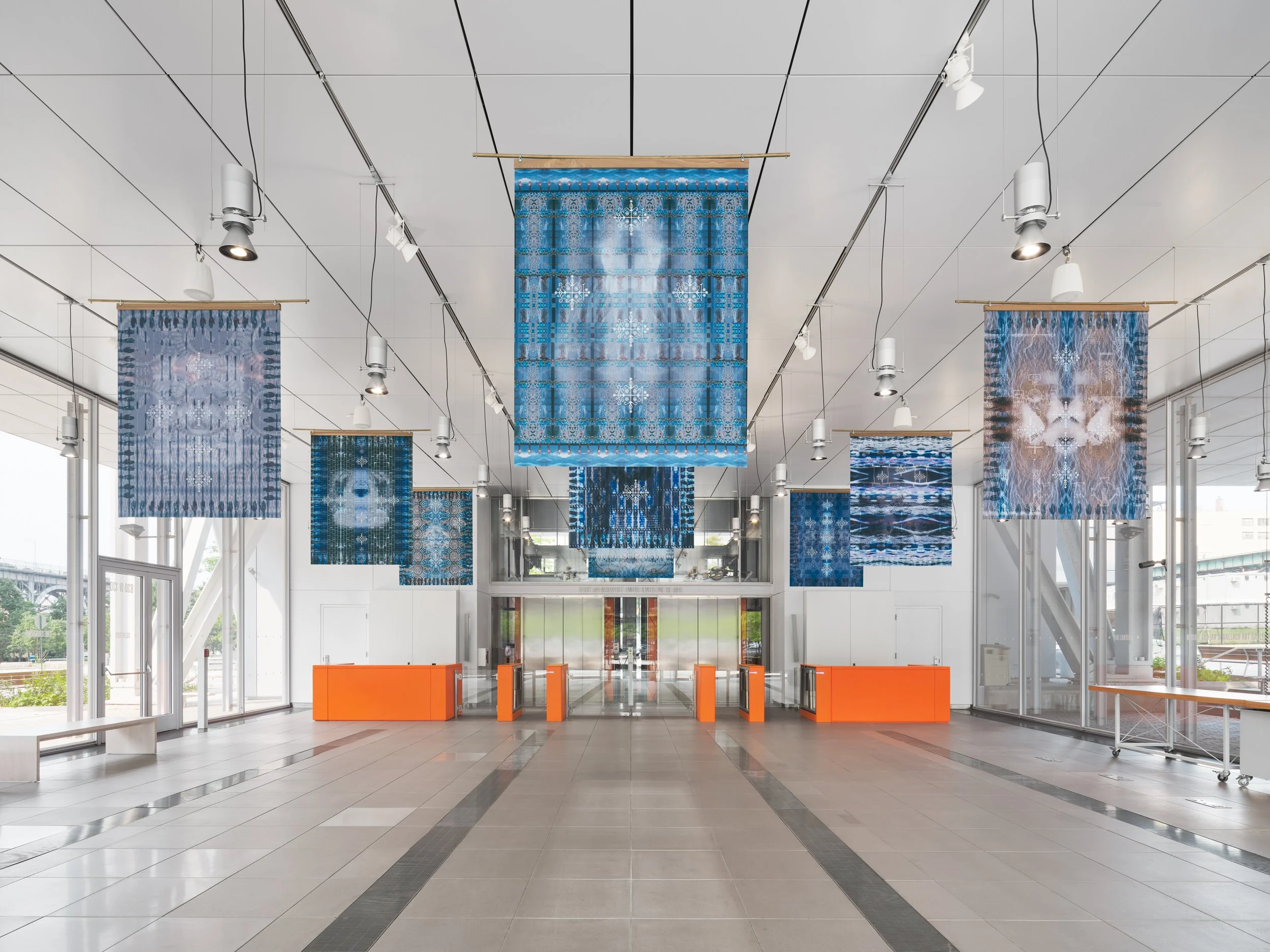 A series of banners hang in the lobby of a building.