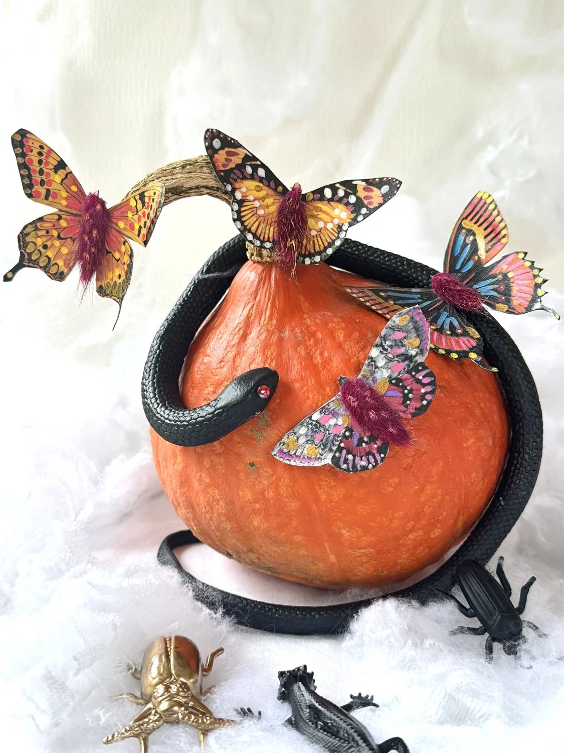 Papillons en papier et fleurs séchées aux détails dorés pour une décoration d’Halloween