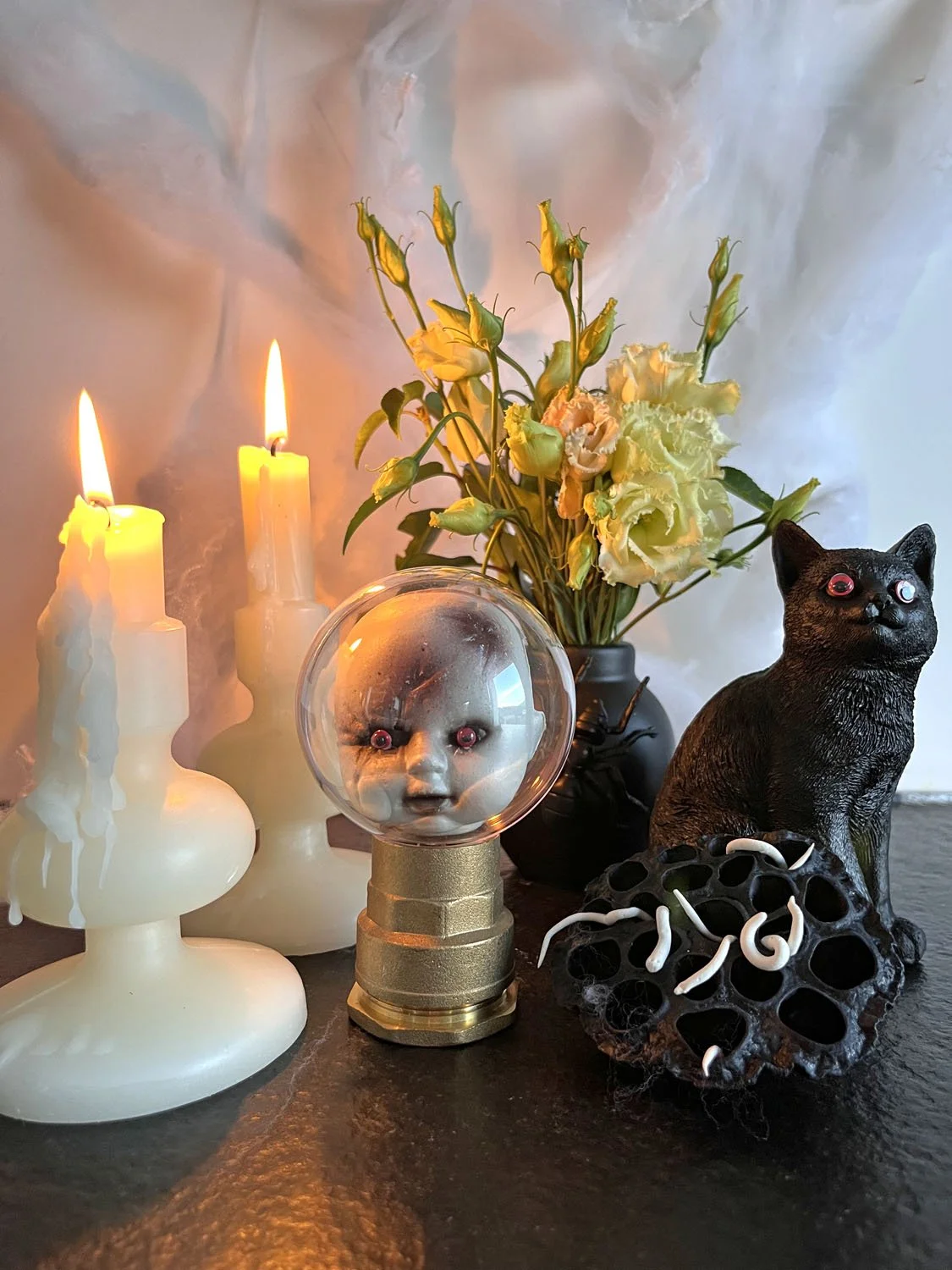 Un DIY pour créer une décoration d’Halloween avec une fleur de lotus peinte en noire et des petits vers en pâte auto-durcissante