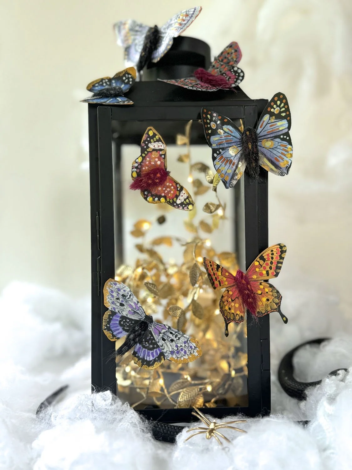 Papillons en papier et fleurs séchées aux détails dorés pour une décoration d’Halloween