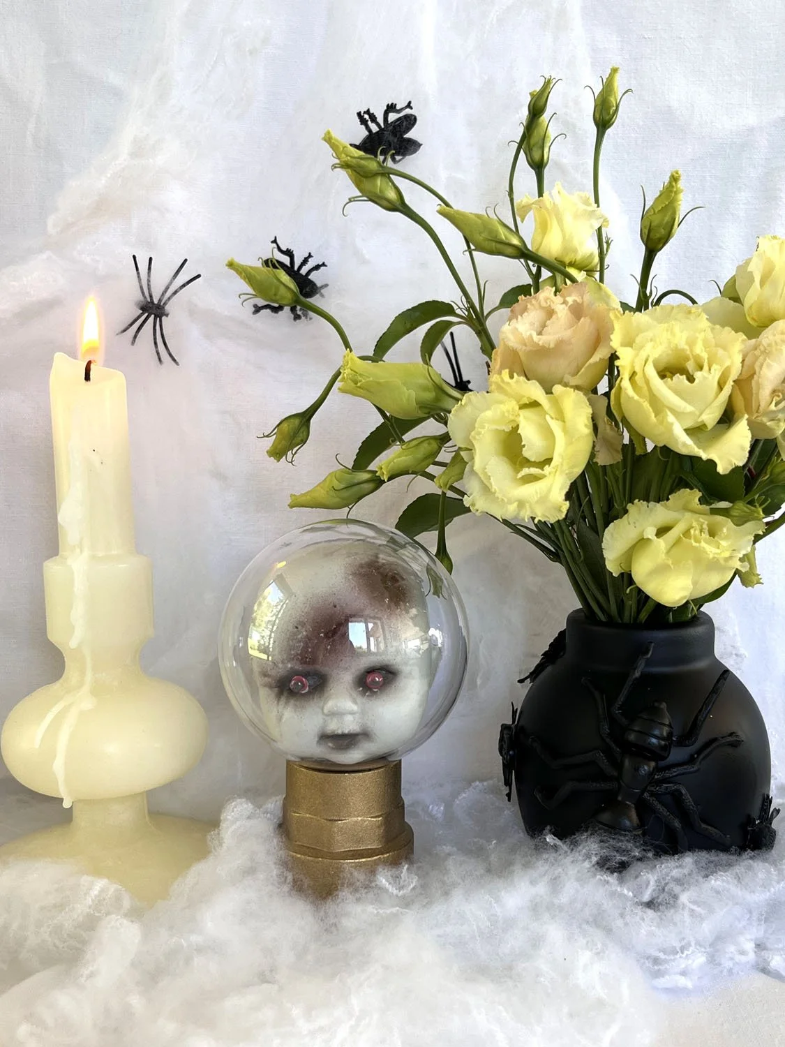 Tête de poupée aux yeux rouges enfermée sous un globe transparent pour Halloween