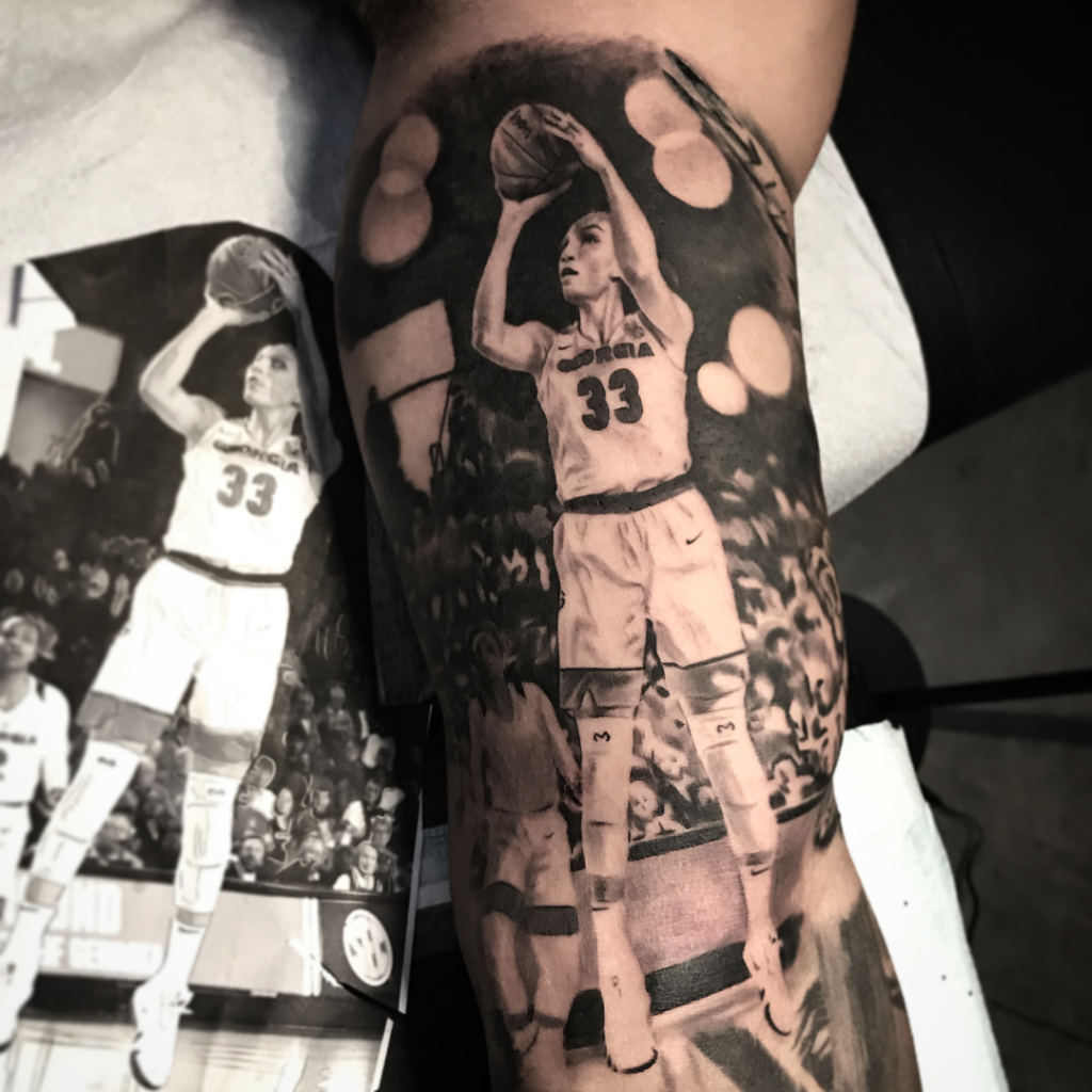 realism Tattoo of a female basketball player in jersey number 33, preparing to shoot a basketball. Keith Hernandez