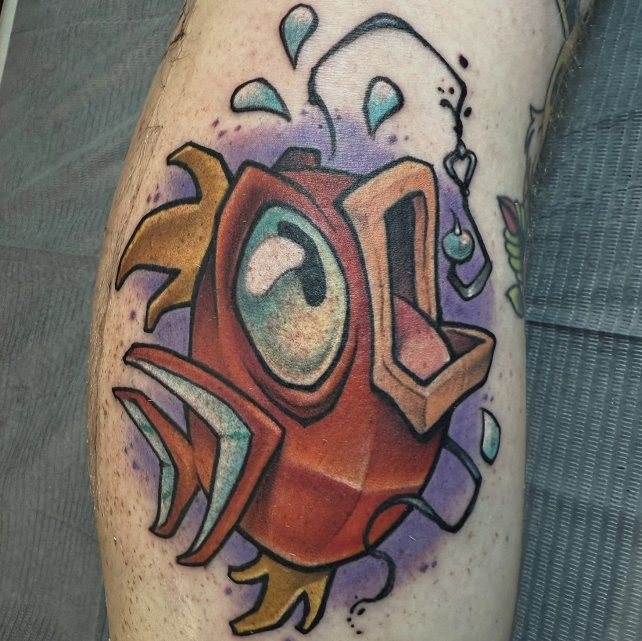 new school tattoo of a fish with colorful geometric shapes, and splashes of purple background.