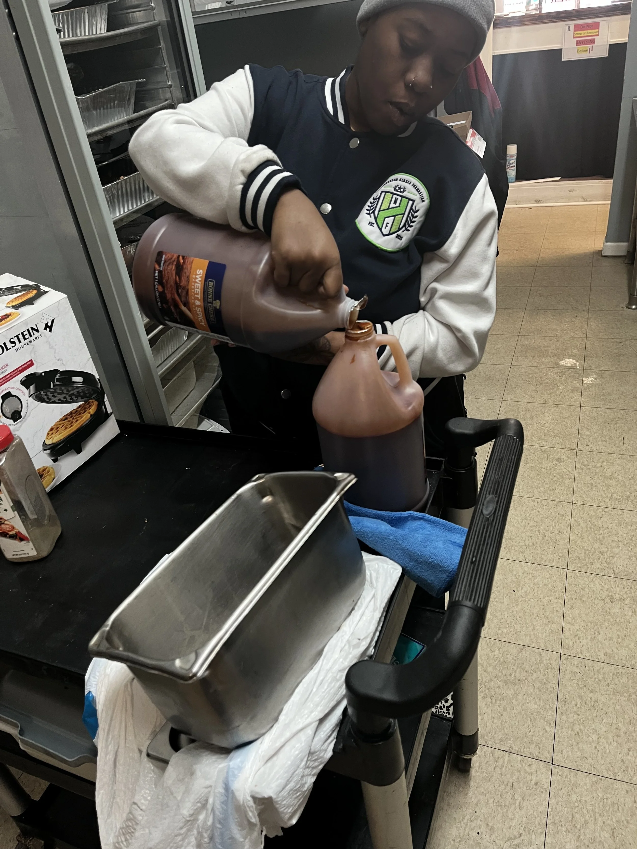 JWBYI's Culinary Arts Outreach Program refilling bottles.