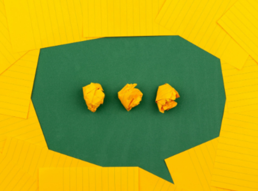 Three crumpled yellow pieces of paper on a green background with a yellow patterned border.