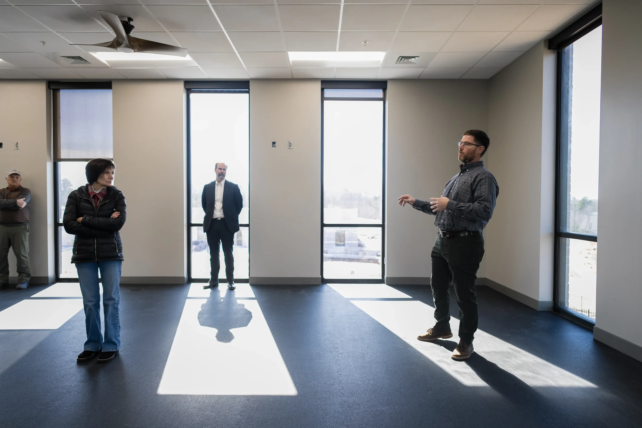Three professionals discussing a commercial space during a building walkthrough with natural light
