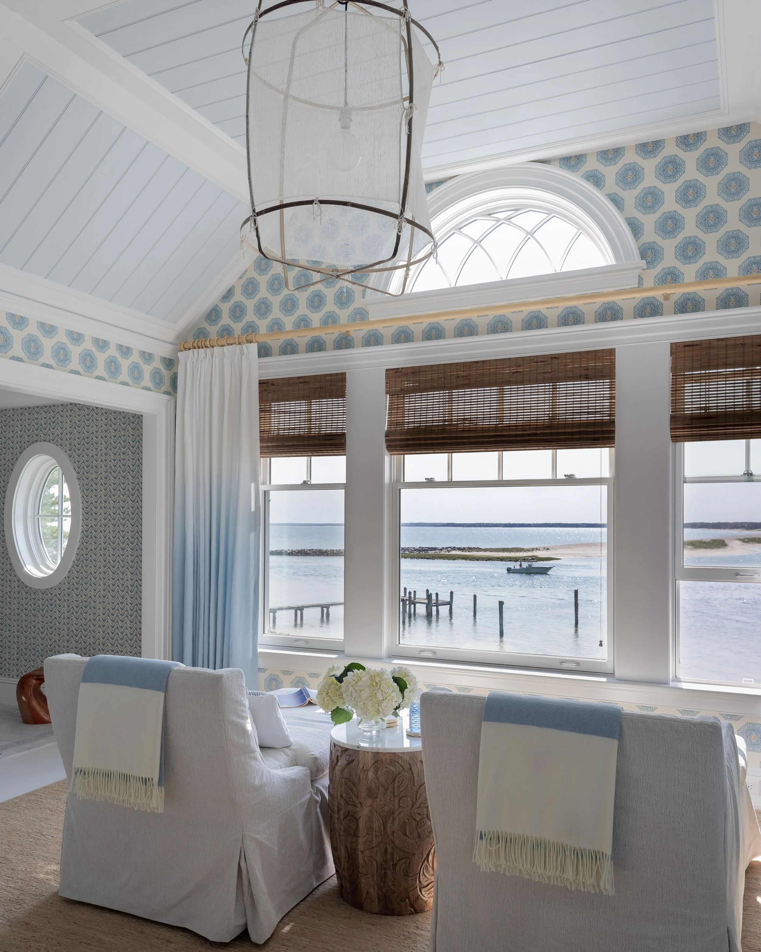 Inside or out, the invitation is the same: take a seat and stay with the view. This bedroom and porch were designed to feel connected by the bay, creating two quiet moments for slowing down and taking it all in.

Interior design: @robingannoninterior