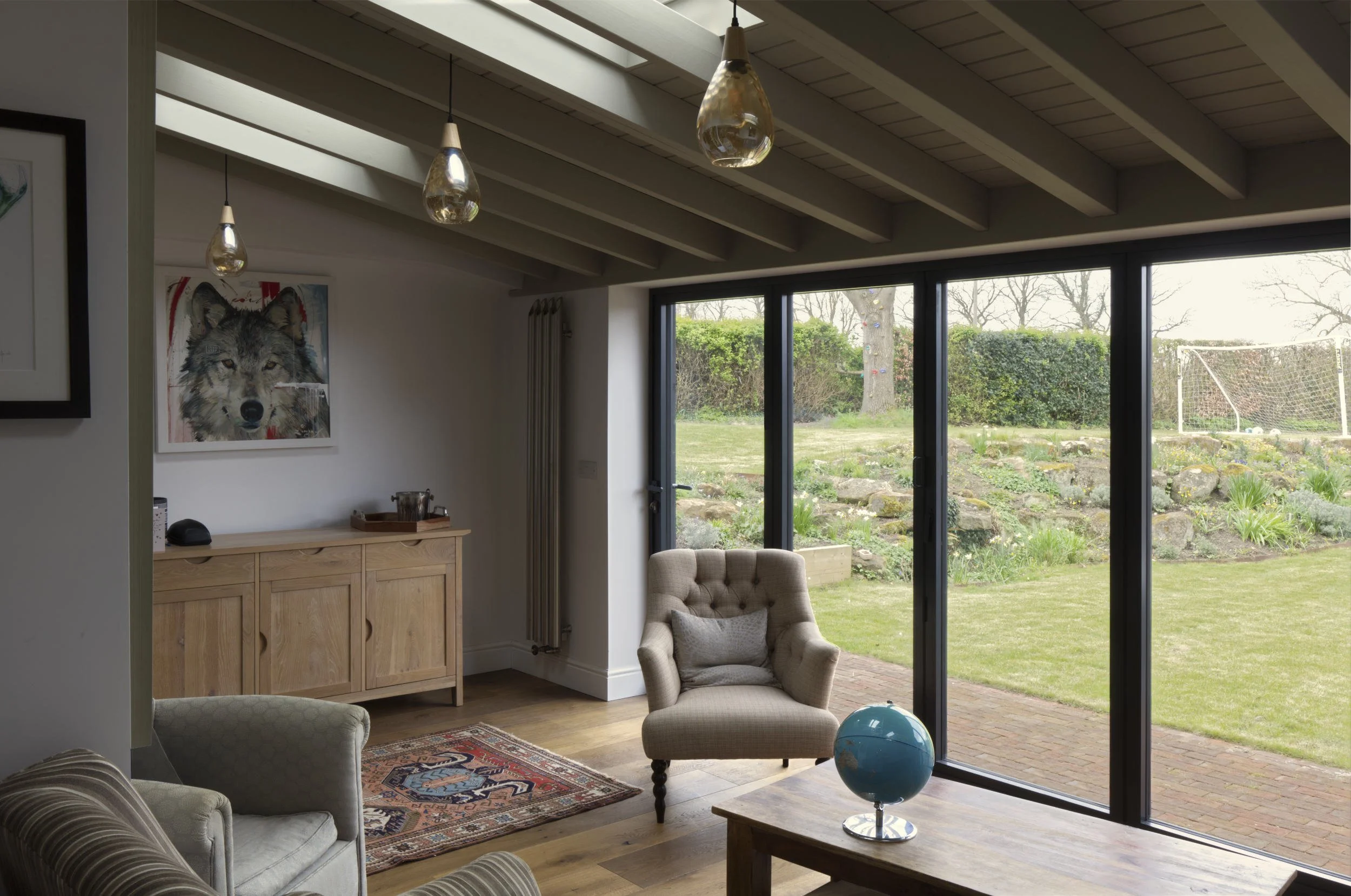 Exposed timber roof structure and view of the garden.