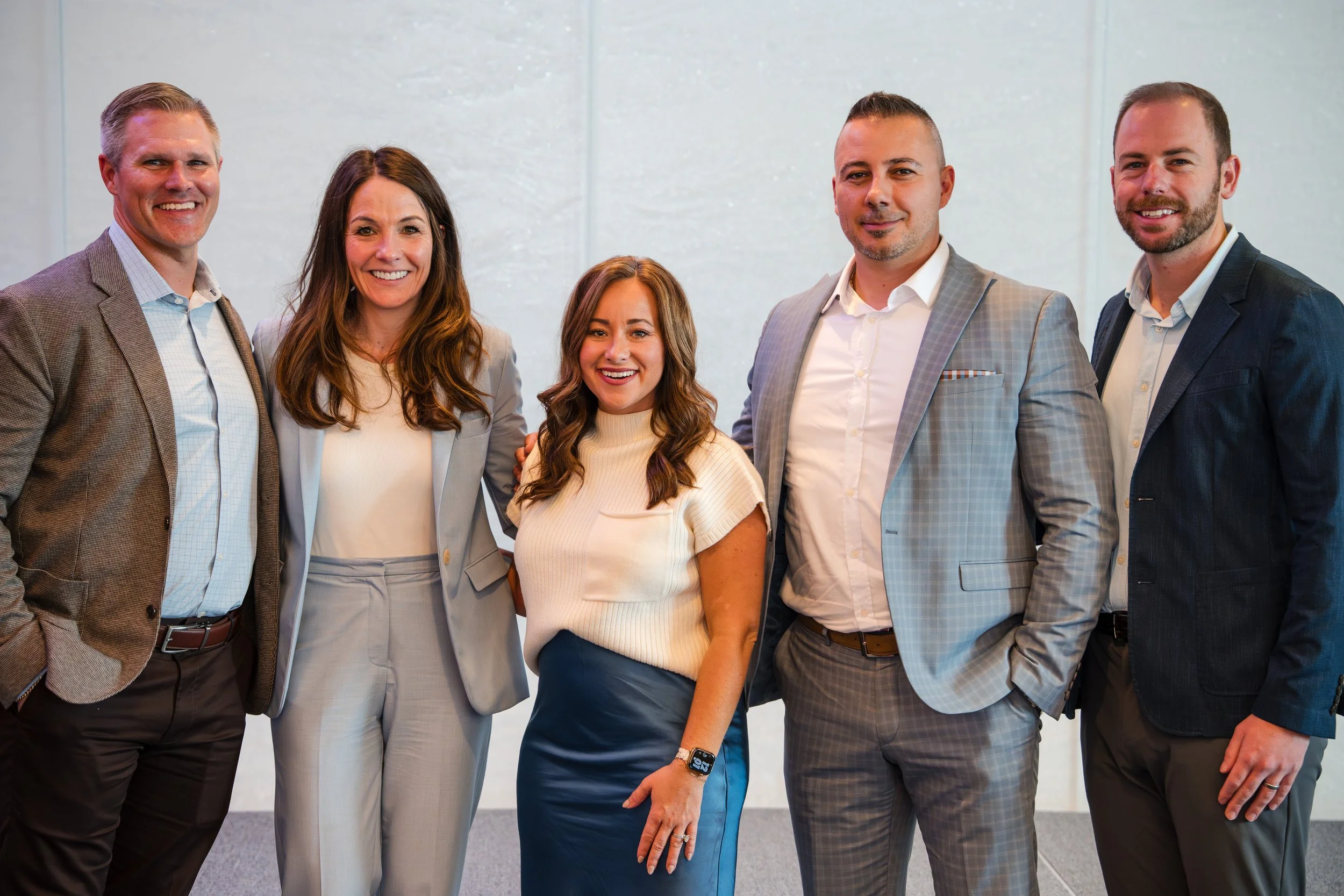 Corporate leadership team on stage posing together during conference event