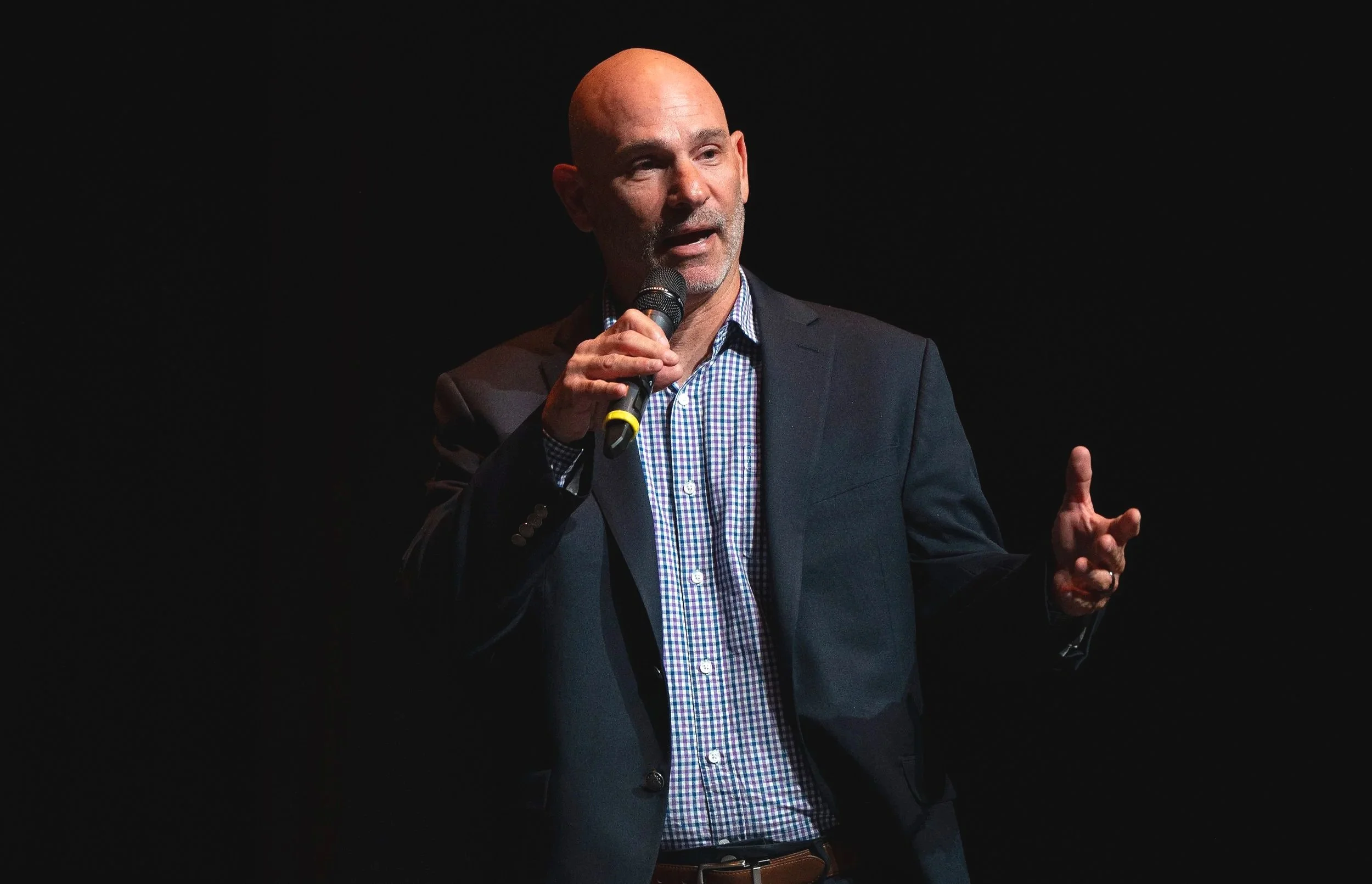 Corporate media team filming a professional business event with polished lighting and production equipment