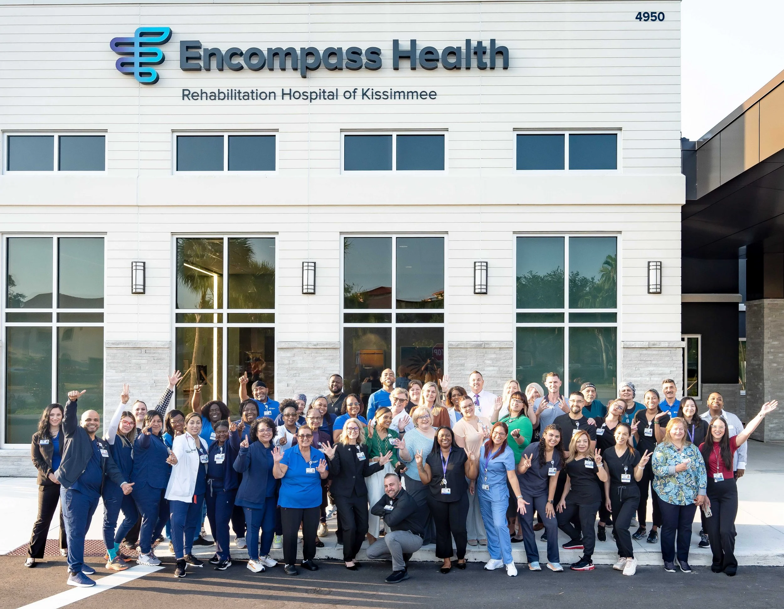 Large corporate team group photo outside business headquarters